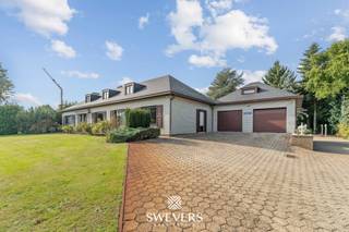 Voor meer info en foto’s, surf naar www.swevers.be – Aan de Helzoldstraat 92 in Houthalen-Helchteren wacht een ruime open bebouwing op een perceel van bijna 40 are. Met een bewoonbare oppervlakte van 412 m² en een kelder van 209 m² is deze woning ideaal voor grote gezinnen, zelfstandigen of wie op zoek is naar extra wooncomfort. De woning werd deels vernieuwd in 2017 (verwarmingsinstallatie, keuken, badkamer, vloeren) en recent in 2024 voorzien van nieuwe ramen en elektrische rolluiken. Op het gelijkvloers tref je een ruime inkomhal, aparte vestiaire, lichtrijke leefruimte van 50 m², een vernieuwde keuken, drie slaapkamers, een badkamer, een apart toilet, een bijkeuken en een bureauruimte. Op de eerste verdieping is een aparte woonunit met leefruimte, keuken, badkamer en grote slaapkamer, perfect voor kangoeroewonen of dubbele bewoning. De kelder met dubbele garage is volledig uitgerust en toegankelijk via 2 sectionale poorten – ideaal als werk- of opslagruimte. Buiten geniet je van een prachtig aangelegde tuin met sproei-installatie, ruime oprit, extra garage en veel privacy. De woning ligt op korte afstand van winkels, scholen, ontspanning en de E314. Voor meer informatie, bel 011 255 155. Bron bewoonbare oppervlakte: EPC – verslag.