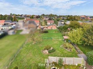 Voor meer info en foto’s, surf naar www.swevers.be – Vrijheerstraat 24 in Sint-Truiden biedt gelijkvloers wonen op een uitzonderlijk ruim perceel van 2.624 m². Deze open bebouwing uit 1968 ligt rustig en landelijk tussen Sint-Truiden en Heers, vlak bij de N3. De woning heeft een bewoonbare oppervlakte van 132 m², onderging al enkele opfrisbeurten maar heeft ruimte om verder naar eigen smaak te moderniseren. Via de centrale inkomhal bereik je de ruime leefruimte van 37 m² met plaats voor een comfortabele zit- en eethoek. Aansluitend bevindt zich de vernieuwde keuken van 11 m². Verder zijn er een badkamer met inloopdouche, een praktische berging en twee volwaardige slaapkamers van 12,60 m² en 14,40 m². Een zolder, bereikbaar via buiten, en een bijgebouw zorgen voor extra opslagruimte. De dubbele garage biedt plaats aan twee wagens. Een absolute troef is de grote, zuidwestelijk georiënteerde tuin. Dankzij de royale oppervlakte zijn er tal van mogelijkheden voor een terras, speelruimte, moestuin of groene ontspanningszones. Ook de ligging is praktisch: scholen bevinden zich op ca. 600 meter, openbaar vervoer op 800 meter, restaurants op 2 km en winkels op ongeveer 4 km. De snelweg (E40) ligt op circa 5,7 km. Een interessante woning voor wie ruimte, rust en gelijkvloers comfort zoekt en graag zelf verder vorm geeft aan zijn toekomstige thuis. Voor meer informatie, bel 011 255 155. Bron bewoonbare oppervlakte: EPC – verslag. Dit pand is onderworpen aan de renovatieverplichting van de Vlaamse overheid voor residentiële gebouwen (behoudens bij sloop binnen 5 jaar na de aankoop). Consulteer voor meer informatie de website van het Vlaams Energie- en Klimaatagentschap via https://www.vlaanderen.be/een-huis-of-appartement-kopen/renovatieverplichting-voor-residentiele-gebouwen.