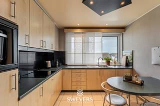 Interesse? Meer informatie op www.SWEVERS.be. - Dit instapklare appartement op de derde verdieping aan de Grote Baan in Houthalen-Helchteren biedt 116 m² wooncomfort op een zeer centrale locatie. De ruime en lichtrijke leefruimte van 35 m² met airco sluit aan op een praktische, gerenoveerde open keuken. Het appartement beschikt over drie volwaardige slaapkamers, een vernieuwde badkamer en is onmiddellijk bewoonbaar.<br /><br />Extra troeven zijn de twee terrassen (10 m² vooraan en 3 m² achteraan), elektrische rolluiken, vliegenramen, lift, een vrijstaande garage en een kelderberging. Dankzij privé zonnepanelen (2022) en een gunstig EPC is het appartement energiezuinig.<br /><br />Met scholen, openbaar vervoer, winkels en ontspanning op wandelafstand en een vlotte verbinding naar de snelweg, combineert deze woonst ruimte, comfort en een uiterst praktische ligging. Bel ons vandaag nog voor een persoonlijke rondleiding. Wij van Swevers Real Estate helpen je maar al te graag verder. tel. 011 255 155. Bron bewoonbare oppervlakte: EPC-verslag.