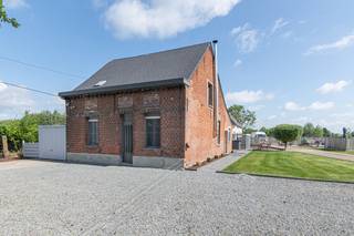 In het landelijke Hombeek, in een rustige straat, bevindt zich deze charmante open bebouwing op een perceel van ± 1600 m². De woning is omgeven door weilanden en groen, waardoor je hier geniet van maximale rust, privacy en een open zicht op de omliggende natuur.<br /><br />De woning is functioneel ingedeeld en biedt tal van mogelijkheden. De kelder zorgt voor praktische opbergruimte. Op het gelijkvloers vind je een gezellige leefruimte, een ingerichte keuken, een badkamer en een extra kamer die perfect kan dienen als slaapkamer of bureau – ideaal voor wie gelijkvloers wil wonen of nood heeft aan een thuiswerkplek. Op de bovenverdieping bevinden zich een overloop en een slaapkamer met aangename lichtinval en uitzicht op het groen.<br /><br />Op het perceel is bovendien een ruime loods aanwezig, wat een grote meerwaarde vormt voor wie op zoek is naar extra werk- of opslagruimte.<br /><br />De ligging combineert rust met een vlotte bereikbaarheid. Winkels, scholen en openbaar vervoer bevinden zich in de nabije omgeving, en via de E19 en R6 bereik je snel Mechelen, Brussel en Antwerpen.<br /><br />Belangrijke informatie:<br />De woning is momenteel vergund als landbouwwoning en gelegen in agrarisch gebied. Bij een aankoop met het oog op gebruik als ééngezinswoning dient eerst een opname als vergund geachte woning in het vergunningenregister te gebeuren, waarna een functiewijziging naar residentieel gebruik aangevraagd moet worden.<br /><br />Ben je op zoek naar een woning in een groene omgeving met ruimte, potentieel en extra mogelijkheden? Dan is dit pand zeker een bezoek waard.