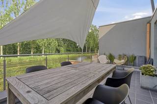 This property includes a commercial ground floor and a separate residential unit on the upper floors, each with its own entrance and already rented out. As a result, you will immediately enjoy a stable rental income. Commercial property (Ground floor)The single-storey commercial building of approximately 80 m² offers an open and flexible layout, suitable for various professional applications. The presence of air conditioning ensures comfort, while a courtyard at the rear offers additional options. In addition, the commercial property has a separate entrance and a spacious 50 m² basement, ideal as a storage space.Residence (Duplex Apartment of 155 m²)The duplex apartment has a generous living area of 155 m², a spacious terrace with a beautiful view of the water and has 3 full bedrooms. There is also a double garage. Duplex apartment layout1st floor- Entrance hall- Guest toilet- Living space- Open kitchen2nd floor: - 3 bedrooms- Bathroom equipped with bath and walk-in shower