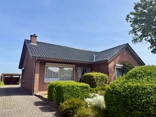 In een rustige, aangename straat in Wijchmaal (Peer) vind je deze bungalow uit 1975. Het huis is gelegen op een perceel van 8 are met een bewoonbare oppervlakte van +/- 111 vierkante meter. De woning combineert een praktische indeling met een groene, ontspannen leefomgeving.<br /><br />Bij binnenkomst stap je de ruime hal in, die toegang biedt tot de keuken, met aansluitend een koele berging. Vanuit de keuken kom je in een ruime en lichtrijke living. De keuken sluit aan op de achteringang, die directe toegang biedt tot de tuin. Verder zijn er drie slaapkamers, een badkamer, een apart toilet, een grote wasplaats en garage met toegang tot zolder en kruipkelder. <br />De woning is in living en keuken voorzien van dubbele beglazing. Overal zijn rolluiken aanwezig. Het dak werd<br />vernieuwd in 2016 (met extra isolatie op de welfsels).<br /><br />De tuin is zonder twijfel een troef: met verschillende terrassen, een tuinhuis en een carport, en altijd keuze tussen zon of schaduw. De tuin vormt een echte oase van rust. Perfect voor wie houdt van buitenleven en gezelligheid! Winkels, scholen, openbaar vervoer en restaurants zijn vlakbij. Hierdoor geniet je van zowel rust als praktische nabijheid. Het huis ligt centraal tussen Peer en Hechtel-Eksel. Daarnaast is de N74 snel en makkelijk bereikbaar.<br />Deze bungalow is ideaal voor wie op zoek is naar een woning met veel buitenruimte op een uitstekende locatie.<br /><br />Contact: 0485/45 77 40