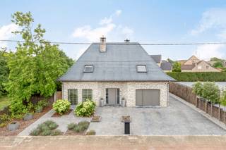 Welkom in deze moderne, instapklare villa uit 1995 van 243m² (excl. garage)op een perceel van 851m² in de Spiltstraat 55 te Zemst. Deze woning onderscheidt zich door de hoge afwerkingsgraad, uitstekende staat van onderhoud en prachtig aangelegde zuidwestgerichte tuin met zwembad en poolhouse. U wordt verwelkomd via een ruime inkomhal met gastentoilet en vestiaire. De lichtrijke leefruimte met gashaard en parketvloer straalt warmte en gezelligheid uit. Vanuit de veranda (2014) geniet u van een panoramisch zicht op de tuin dankzij de grote raampartijen die de ruimte overladen met natuurlijk licht. Alle ramen op het gelijkvloers werden in 2017 vernieuwd en een aantal zijn voorzien van automatische screens. Aansluitend vindt u de volledig uitgeruste keuken met Miele-toestellen (2011), inclusief een stoomoven, klassieke oven, vaatwas op hoogte, grote koelkast en een mooi kookeiland met inductie kookplaat. Naast de keuken bevindt zich een praktische bijkeuken/berging en een ruime garage/berging. Op de eerste verdieping vindt u een nachthall met bureauhoek (15 m²) en 3 ruime slaapkamers, waaronder een master bedroom van 17 m² met ingebouwde kasten en twee kamers van elk 15m². De badkamer werd vernieuwd in 2021 en is uitgerust met een inloopdouche, dubbele wastafel, toilet en vloerverwarming. Daarnaast zijn op de verdieping ook alle veluxen voorzien van automatische rolluiken. De zuidwestgerichte tuin biedt heel wat ontspanning met een overdekt terras (25m²) met louvredak, verwarmd zwembad (2005) en een poolhouse (23m²) met douche en sauna. De woning is zeer energiezuinig met een EPC-label A en beschikt over 48 zonnepanelen (2016). Andere voorzieningen zijn: een waterverzachter, elektrische boiler, ... De centrale ligging in Zemst combineert rust en groen met een uitstekende bereikbaarheid richting Mechelen, Brussel en Antwerpen. Scholen, winkels, sportfaciliteiten en natuur zijn bovendien vlakbij. Elektrische installatie is conform!