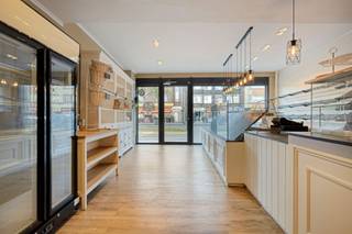 <p><span>Op een commerciële locatie aan de Bredabaan in Merksem bevindt zich dit ruime handelspand van ca. <strong>294 m²</strong>, momenteel ingericht als bakkerij met tearoom. Het pand wordt verkocht <strong>inclusief de aanwezige professionele bakkerij-uitrusting</strong> en biedt zo een uitstekende opportuniteit voor wie een volledig ingerichte zaak wil overnemen.</span></p><p><span>Het gelijkvloers bestaat uit een recent gerenoveerde winkelruimte met ruime toonbank, glazen vitrines en een verzorgde afwerking. Aansluitend bevindt zich de tearoom met zitplaatsen en een bijkomend verkoopgedeelte met koelvitrines.</span></p><p><span>Achteraan bevindt zich het volledig uitgeruste bakkerijatelier met onder meer dekovens, industriële deegmengers, rijskasten, inox werkbladen, professionele vaatwasser en ruime opslagmogelijkheden. Daarnaast zijn er afzonderlijke toiletten voor dames en heren.</span></p><p><span>Via een interne trap bereik je de bovenverdieping, die bijkomende ruimte biedt voor opslag of andere invullingen.</span></p><p><span>Het pand beschikt over een vernieuwde Vaillant condensatieketel. Het platte dak en de gevels bieden nog mogelijkheden om de energieprestaties verder te verbeteren.</span></p><p><span>Dankzij de ruime oppervlakte, commerciële ligging en volledige inrichting is dit pand ideaal voor een bakker die onmiddellijk van start wil gaan, maar eveneens interessant voor andere handels- of horecaconcepten.</span></p><p><span><strong>Bijzonderheden:</strong></span><br /><span>294 m² | Professionele bakkerij-uitrusting inbegrepen | Tearoom | EPC E | Vaillant condensatieketel | Plat dak | Bestemming horeca | EPC, asbestattest en elektrisch keuringsverslag beschikbaar | Renovatieverplichting van toepassing.</span></p>