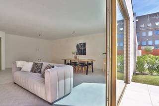 Dit <strong>gelijkvloers nieuwbouwappartement</strong>, recent opgeleverd binnen het BEN-project “<em>Het Perron</em>”, combineert comfortabel wonen met een uitstekende ligging aan het station, de fietsostrade en op wandelafstand van het centrum van Beveren.<br /><br />Het appartement beschikt over een <strong>bewoonbare oppervlakte van 105,25 m²</strong> en omvat <strong>twee slaapkamers</strong>. De aangename leefruimte geeft uit op het <strong>ruime zuidwest georiënteerde terras van 13,6 m²</strong>, dat <strong>afgebakend is met een haagje</strong>, waardoor u in alle privacy kan genieten van het buitenleven. De terrassen en tuintjes van de gelijkvloerse appartementen zijn bovendien gelegen in een grote, afgesloten gemeenschappelijke tuin, wat zorgt voor een groene, rustige en veilige woonomgeving.<br /><br />De <strong>keuken kan nog volledig naar eigen smaak en budget gekozen worden</strong>. <strong>Bovenop het bestaande keukenbudget geniet u bovendien van een extra keukenbudget ter waarde van € 5.000</strong>, waardoor u nog meer vrijheid heeft om uw droomkeuken samen te stellen.<br /><br />Op technisch vlak is het appartement uitgerust met <strong>vloerverwarming</strong>, een <strong>energiezuinige warmtepomp</strong>, <strong>zonnepanelen</strong> en een <strong>ventilatiesysteem type D</strong>, wat garant staat voor een aangenaam binnenklimaat, een laag energieverbruik en maximaal wooncomfort.<br /><br />Dankzij het <strong>BEN-label (E-peil max. E10)</strong> woont u hier bijzonder energiezuinig en toekomstgericht. Dit vertaalt zich niet alleen in lagere energiekosten, maar ook in <strong>financiële voordelen</strong>, zoals <strong>100% korting op de onroerende voorheffing gedurende 5 jaar</strong>.<br /><br />Daarnaast beschikt het project over een <strong>volledige ondergrondse parking</strong>, rechtstreeks toegankelijk vanuit het gebouw, met <strong>autostaanplaatsen, kelderbergingen en fietsenstallingen</strong>.<br /><br />Dit appartement komt bovendien in aanmerking voor de <strong>6% BTW*-regeling voor eigen bewoning</strong>.<br />Ook is het een interessante opportuniteit met <strong>6% BTW* voor investeerders</strong>! Geniet van een verlaagd BTW-tarief mits <strong>15 jaar verhuur</strong>, wat zorgt voor een lagere instap en een aantrekkelijk rendement op lange termijn.<br />(*mits voldaan wordt aan de wettelijke voorwaarden)<br /><br />Bent u op zoek naar een instapklaar, energiezuinig gelijkvloers appartement met 2 slaapkamers, een privatief terras, moderne technieken en een groene gemeenschappelijke tuin op een topligging?<br />Graag laten we u dit appartement persoonlijk ontdekken. Neem gerust contact met ons op voor bijkomende informatie of een bezoek via verkoop@homevast.be of tel. 03 344 77 44.