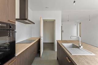 Deze charmante duplexwoning, met inkom aan de Ambachtsstraat, combineert een klassieke indeling met moderne technieken en energiezuinig comfort. <br /><br />Op het gelijkvloers vormen de volledig ingerichte keuken, eetruimte en zitplaats een open en luchtig geheel met zicht op de tuin. Een grote voorraadberging grenst aan de keuken en de technische installaties zijn netjes ondergebracht in een aparte berging.<br /><br />Achteraan bevindt zich een zuidgerichte stadstuin met ommuurd terras en een poortje naar de straat – ideaal voor privacy. Via de tuin heb je directe toegang tot een zeer ruime garage ( aan te kopen voor €40.000,-), geschikt voor een wagen, meerdere fietsen, afvalcontainers en met voorziening voor een laadpaal, aangesloten op de meter van de woning.<br /><br />Op de verdieping vinden we twee slaapkamers met parket en een comfortabele badkamer met dubbele wastafel, douche en extra toilet – perfect voor gezinnen of koppels.<br /><br />Kwaliteit en duurzaamheid gegarandeerd:<br /><br />*Vloerverwarming mét vloerkoeling, warmtepomp en zonnepanelen inbegrepen.<br />E-peil 10 (ver onder de norm), wat betekent: 5 jaar vrijstelling van onroerende voorheffing.<br /><br />Een comfortabele, energiezuinige woning op een centrale locatie – klaar om jouw thuis te worden!<br /><br />Aankoop mogelijk aan 6% BTW