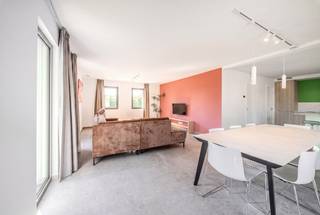 In het hart van het dorp Saint-Ode, op enkele minuten van Bastogne, ontwikkelt dit recent gebouwde rijtjeshuis van ±180 m² een gezinsvriendelijke leefomgeving in een groene omgeving. De ruimtes, lichtinval en voorzieningen voldoen aan de verwachtingen van een eigentijdse, comfortabele en energiezuinige woning.<br /><br />Op de begane grond bevindt zich een mooie leefruimte met een volledig uitgeruste open keuken. Grote ramen verlengen de ruimtes naar het terras en de privétuin. Op de bovenverdieping bieden vier slaapkamers en twee badkamers een passende indeling voor het gezinsleven. Een garage met gemotoriseerde sectionaaldeur maakt het pand compleet.<br /><br />Op technisch vlak beschikt de woning over 12 fotovoltaïsche panelen, hoogwaardige PVC-kozijnen, leistenen dakbedekking, een alarmsysteem en afstandsbedieningen. De woning verkeert in uitstekende staat en vereist geen werkzaamheden. Winkels, scholen en wegen zijn gemakkelijk bereikbaar, met Bastogne op slechts enkele minuten afstand.