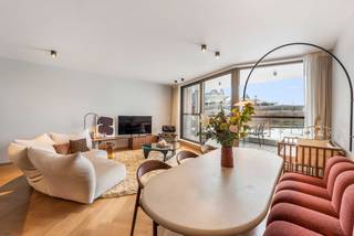 ONDER OPTIE<br />Luxueus afgewerkt appartement - topligging op 't Zuid<br /><br />Modern en lichtrijk appartement (112 m²) met 2 terrassen, 3 slaapkamers en fenomenaal uitzicht op het park – gelegen op ‘t Zuid op de voormalige Zillion - site, 2000 Antwerpen.<br /><br />Op een topligging op het trendy Zuid presenteert zich dit afgewerkte en instapklare appartement van 112 m² plus terrassen, gekenmerkt door modern design, hoogwaardige afwerking en een uitzonderlijke lichtinval. Het appartement bevindt zich in een energiezuinig gebouw met bouwjaar 2020.<br /><br />Bij binnenkomst ontvouwt zich een ruime inkomhal met ingewerkte maatkasten. De vloer is bekleed met een massief eiken visgraatparket dewelke doorheen het gehele appartement loopt.<br /><br />Vervolgens kom je uit in de hyper uitgeruste open keuken en aansluitende, luchtige leefruimte met grote raampartijen die uitkijken op een prachtig panoramisch zicht over het park en het vlinderpaleis.<br />Op het zuid-georiënteerde ruime terras dat aan de woonkamer grenst, geniet je de volledige dag van de zon.<br /><br />De open keuken is een absolute blikvanger: voorzien van een stijlvol marmeren Fior di Bosco - werkblad, Quooker-kraan en met hoogwaardige toestellen zoals een Miele inductie kookplaat en een ingebouwde wijnkoeler. Een aparte bergruime sluit aan op de keuken.<br /><br />Het appartement beschikt over drie slaapkamers (7, 9 en 17 m²). De master bedroom beschikt over ingewerkte maatkasten en sluit aan op de ensuite badkamer met dubbele lavabo en ingewerkte designkranen.<br /><br />In de nachthal tref je ook een aparte douchekamer aan met inloopdouche en een aansluiting voor een wasmachine en droogkast. Daarnaast beschikt het appartement over een apart toilet met handenwasser.<br /><br />Het energiezuinige gebouw is aangesloten op het warmtenet en het volledige appartement is voorzien van vloerverwarming. <br />Video beschikbaar via instagram: https://www.instagram.com/theresidence_antwerp<br />Voor meer info kan u contact opnemen via Immoscoop of e-mail: wimbillen@outlook.com