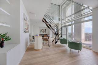 <p><span>Met gepaste trots stellen wij u graag dit exclusieve penthouse voor.<br /><br />Gelegen op een absolute toplocatie tussen het bruisende Eilandje en het groene Park Spoor Noord, vinden we residentie Lichttoren. Op de 20ste en 21ste verdieping bevindt zich deze uitzonderlijke duplex-penthouse, waar ruimte, licht en hedendaags comfort worden gecombineerd met indrukwekkende vergezichten over de Antwerpse skyline.<br /><br />INDELING</span></p>
<p><span>Via de stijlvolle inkomhal, voorzien van een ingebouwde vestiaire, gastentoilet en handenwasser, komt u terecht in een bijzonder ruime leefruimte. De hoge raampartijen zorgen hier voor een overvloed aan natuurlijk licht en bieden vanuit verschillende hoeken een prachtig zicht over de stad. De royale terrassen sluiten naadloos aan bij de leefruimte en vormen een verlengstuk van het interieur.</span></p>
<p><span>De leefruimte is sfeervol ingedeeld met een salon, eetgedeelte en een stijlvolle bar. De open trap naar de verdieping vormt een opvallend architecturaal element en geeft het geheel een eigentijdse uitstraling.</span></p>
<p><span>De open keuken sluit mooi aan bij de leefruimte en werd uitgerust met een centraal kookeiland en kwalitatieve inbouwtoestellen. Zo beschikt de keuken onder meer over een inductiekookplaat met geïntegreerde dampkap, koelkast, heteluchtoven, microgolfoven, vaatwasser en spoelbak. Functionaliteit en esthetiek komen hier mooi samen.</span></p>
<p><span>Op de bovenste verdieping bevindt zich een multifunctionele ontspanningsruimte van ca. 32m². Dankzij het aanwezige monkeynet en de filmprojector is dit een ideale plek om te ontspannen of gezellig samen te komen. De grote raampartijen zorgen ook hier voor een spectaculair uitzicht over Antwerpen.</span></p>
<p><span>De master bedroom is opgevat als een volwaardige privésuite en staat rechtstreeks in verbinding met de open badkamer. Deze beschikt over een dubbele lavabo, ligbad, regendouche, ingemaakte kasten en elektrische gordijnen. Daarnaast is er nog een tweede slaapkamer en een afzonderlijke douchekamer met lavabo. De nachthal beschikt over een extra toilet en een praktische ingemaakte kast met aansluitingen voor wasmachine en droogkast.<br /><br /></span>In de kelder beschikt het penthouse over een privatieve berging van ca. 8m² en toegang tot een fietsenberging. Daarnaast is er de mogelijkheid om meerdere autostaanplaatsen aan te kopen, wat zorgt voor extra parkeergelegenheid en comfort. Prijzen zijn beschikbaar op aanvraag.</p>
<p><span>Ook op vlak van comfort is deze penthouse bijzonder compleet. Zo zijn er airconditioning in de leefruimte en master bedroom, elektrische zonwering, dimbare opbouwverlichting en een ventilatiesysteem type D.</span></p>
<p><span>Een uitzonderlijke duplex voor wie op zoek is naar een instapklare en luxueuze woonervaring, met royale buitenruimtes, een hoogwaardige afwerking en een uniek panoramisch zicht over de stad.<br /><br />BIJZONDERHEDEN<br />- Hoogwaardige afwerking<br />- Panoramisch uitzicht over Antwerpen<br />- Absolute toplocatie<br />- Voldoende parkeermogelijkheden en privatieve kelderberging<br /><br />Voor meer info of een bezoek ter plaatse kan u vrijblijvend contact opnemen met Kato via kato@reds.be.</span></p>
