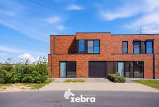 Deze instapklare kijkwoning met inpandige garage en vier slaapkamers bevindt zich in een rustige en aangename woonwijk aan de rand van Roeselare. Met haar moderne architectuur en stijlvolle uitstraling combineert de woning hedendaags wooncomfort met een groene en rustige omgeving, terwijl u toch geniet van een vlotte bereikbaarheid.<br /><br />Bij het binnenkomen komt u terecht in de inkomhal met apart gastentoilet. Aansluitend bevindt zich de ruime en lichtrijke leefruimte die naadloos overgaat in de volledig ingerichte keuken met kookeiland. De keuken is uitgerust met een vaatwasser, combi-oven, koelkast, kookplaat en dampkap. Verder beschikt het gelijkvloers over een inpandige garage.<br /><br />Op de eerste verdieping bevinden zich vier volwaardige slaapkamers, waaronder een ruime master bedroom met maatkasten. Daarnaast is er een ingerichte badkamer voorzien van een ligbad, doorloopdouche en dubbel lavabomeubel. Verder vindt u op deze verdieping nog een apart toilet en een praktische berging.<br /><br />De woning behaalt een uitzonderlijk laag E-peil van -7 dankzij de aansluiting op het stadswarmtenet, vloerverwarming en zonnepanelen van 5.600 WP.<br /><br />Tot slot beschikt de woning over een ruime tuin met terras, grenzend aan een groenzone. De woning wordt bovendien volledig bemeubeld verkocht.<br /><br />* Prijs excl. btw en kosten.<br /><br />Een vrijblijvend gesprek over dit project is mogelijk bij ons op kantoor.