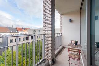 Wonen in alle rust, maar toch vlak bij alles wat de stad te bieden heeft? Dan is dit appartement, met een ligging tussen het historische centrum en het Eilandje, precies wat je zoekt. Het gebouw werd opgeleverd in 2016 en ontleent zijn naam aan de bronzen munten die ooit op deze plek werden teruggevonden. Een knipoog naar het rijke Antwerpse verleden. Het appartement op de derde verdieping voelt licht en ruim dankzij de hoge plafonds en grote ramen. De leefruimte en open keuken vloeien harmonieus in elkaar over en geven uit op het zonnige terras met zicht op het verzorgde groene binnenplein. Met twee volwaardige slaapkamers, een moderne badkamer en een aparte berging biedt dit appartement alle comfort voor eigentijds stadswonen. De poort naar het binnenplein wordt vanaf de avond gesloten voor dat extra veilg gevoel. Kortom: comfortabel en eigentijds wonen in een recente, rustige setting, op wandelafstand van alles wat Antwerpen te bieden heeft. Meer info? Walls.be - Epc: 100,27 kWh/m2 – E64, P-score: C, G-score :C, Stedenbouwkundige informatie in aanvraag