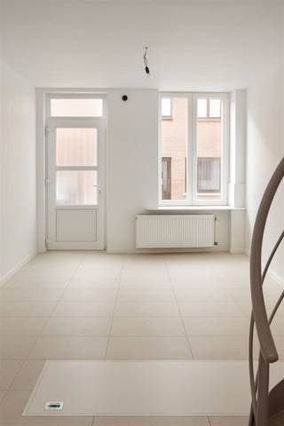 Move-in ready townhouse with 3 bedrooms and outdoor space near downtown!Discover this cozy townhouse with a living area of 76 m², perfectly located within walking distance of the vibrant city center, stores and approach roads.Upon entering you are welcomed into a bright, open living space with an equipped kitchen and a modern spiral staircase to the upper floor. Adjacent is a cozy terrace, ideal for an outdoor coffee moment or practical storage space. On the ground floor you will also find a guest toilet and access to the cellar via a convenient hatch in the living area.On the second floor there is a spacious bedroom of 12.9 m² and a bathroom with toilet, shower, sink unit and connection for the washing machine.The attic offers two additional bedrooms, perfect for a family, office or hobby room.This property is move-in ready, boasts a good EPC score (label B) and a compliant electrical installation an interesting investment opportunity for rental or an ideal starter home!Currently the property is rented out; the current lease should be respected.