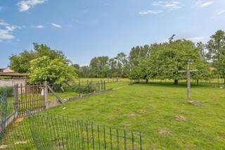 <p>Op een prachtige landelijke ligging in Aspelare bevindt zich deze <strong>gelijkvloerse woning</strong> boordevol potentieel op een ruim perceel van <strong>20 a 20 ca </strong>met <strong>open zicht op het groen</strong>. Deze eigendom is een unieke opportuniteit voor wie op zoek is naar rust, ruimte en tal van mogelijkheden. Dankzij de aanwezige <strong>opslagruimte</strong> is dit pand ideaal voor zelfstandigen, hobbyisten of mensen die nood hebben aan extra stockageruimte. Bovendien biedt het perceel ook interessante ontwikkelingsmogelijkheden: mits afbraak van de bestaande woning en het bekomen van de nodige verkavelingsvergunning, kunnen hier mogelijk <strong>drie bouwgronden</strong> voor halfopen bebouwing gerealiseerd worden. De woning omvat op het gelijkvloers een inkomhal, gezellige living, keuken, veranda met uitzicht op de tuin, slaapkamer, bureau, badkamer, toilet en garage. Het ruime zolderverdiep biedt de mogelijkheid om nog twee tot drie extra slaapkamers te creëren. Daarnaast is er een afzonderlijk schuurtje aanwezig dat perfect kan dienen als opslagplaats of werkruimte. Buiten geniet men van een voortuin, ruime oprit en een diepe tuin waar men volledig tot rust komt met prachtig uitzicht over de <strong>omliggende velden</strong>. Een eigendom met enorm veel potentieel op een uitzonderlijk rustige locatie.</p>