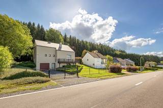 <p><span>Deze ruime woning is gelegen in een groene en rustige omgeving in Nadrin, deelgemeente van Houffalize. De woning beschikt onder meer over een afzonderlijke studio, drie slaapkamers, een inpandige garage en een fraai aangelegde tuin met ruime terrassen, jacuzzi en uitzicht op het achterliggende bos. </span></p>
<p><span>Op het gelijkvloers bevindt zich een ruime inkomhal op tegelvloer, voorzien van een praktische vestiairekast. Van hieruit is er toegang tot de inpandige garage met elektrische sectionale poort, geplaatst in 2010, de wasplaats en de studio.</span></p>
<p><span>Deze studio (32m²), ingedeeld in een woonkamer en een afzonderlijke slaapkamer biedt verschillende mogelijkheden en kan onder meer gebruikt worden als gastenverblijf, thuiswerkruimte, praktijk of bijkomende woonruimte.</span></p>
<p><span>De eerste verdieping omvat een centrale hal met toegang tot de woonkamer, de keuken en een afzonderlijk toilet met handenwasser.</span></p>
<p><span>De ruime L-vormige woonkamer (44m²) wordt gekenmerkt door haar aangename lichtinval en gezellige houtkachel. Vanuit de leefruimte is er rechtstreeks toegang tot het terras en de tuin.</span></p>
<p><span>De leefkeuken is uitgerust met een koelkast met vriesvak, een inductiekookplaat en een dampkap. Aansluitend bevindt zich een bijkeuken met ingemaakte kasten, spoelbak, dampkap, combioven, koelkast en vaatwasser. </span></p>
<p><span>Op de dakverdieping geeft de nachthal toegang tot een afzonderlijk toilet, drie slaapkamers (18,84m², 12m², 15,40m²) en de badkamer. De eerste slaapkamer beschikt over een dressing. De tweede slaapkamer biedt toegang tot een berging. Daarnaast is er nog een derde slaapkamer.</span></p>
<p><span>De ruime badkamer is uitgerust met een ligbad met geïntegreerde douche, een afzonderlijke douchecabine en een dubbele lavabo in meubel met bijhorende kolomkast.</span></p>
<p><span>Ook buiten heeft deze woning heel wat te bieden. De mooi aangelegde tuin is volledig omheind en bereikbaar via een manuele toegangspoort. Het grote houten terras van circa 70 m² heeft een gunstige zuid oriëntatie. Daarnaast is er een tweede terras van circa 14 m² met westelijke oriëntatie, waar u tot ’s avonds van de zon kunt genieten.</span></p>
<p><span>De tuin beschikt bovendien over 2 zonneluifels, een tuinhuis en een jacuzzi. Het open uitzicht over de omgeving zorgt voor een bijzonder aangename en rustgevende sfeer.<br /><br /><span>Extra:</span><br />- Gerenoveerd in 2010<br />- Cv op stookolie<br />- Alarm <br />- Omheind perceel<br />- Elektriciteit conform</span><span></span></p>
<h3><span>Ligging</span></h3>
<p><span>De woning bevindt zich in het hart van de Belgische Ardennen en op korte afstand van het stuwmeer van Nisramont en de Ourthe.</span></p>
<p><span>De omgeving staat bekend om haar uitgestrekte bossen, indrukwekkende vergezichten en talrijke wandel-, fiets- en mountainbikeroutes. Ook het natuurgebied rond Le Hérou, met zijn karakteristieke rotsformaties en prachtige uitzichten over de Ourthe, bevindt zich in de ruime omgeving.</span></p>
<p><span>Wie houdt van wandelen, kajakken, mountainbiken of gewoon genieten van de rust en de natuur vindt hier een uitstekende uitvalsbasis. Tegelijkertijd zijn de centra van Nadrin, Houffalize en La Roche-en-Ardenne vlot bereikbaar voor winkels, horeca en andere dagelijkse voorzieningen.</span></p>
<p><span>Een veelzijdige woning met veel ruimte, mooie buitenvoorzieningen en een uitzonderlijke ligging midden in het groen.<br /><br /></span><span>Stedenbouwkundige inlichtingen in aanvraag.</span></p>