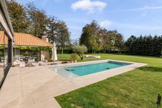 <strong>Exclusieve gerenoveerde villa met zwembad en tennisveld op circa 1,2HA in Sint-Katelijne-Waver.</strong>
<p>Op zoek naar rust, ruimte en luxe in Sint-Katelijne-Waver? Deze volledig <strong>gerenoveerde villa (2022)</strong> combineert <strong>hedendaags comfort met een uitzonderlijk niveau van afwerking</strong>, gelegen op een prachtig privé-domein van circa <strong>1,2 hectare</strong>. Volledige <strong>privacy</strong> en <strong>duurzaamheid</strong> staan centraal in deze unieke eigendom, die werd afgewerkt volgens de hoogste energie- en woonnormen.<br /><br /><strong>Woningkenmerken:<br /></strong><strong>E-peil A</strong> (98kWh/m²)<br /><strong>Warmtepompverwarming<br /></strong><strong>68 zonnepanelen</strong> (10.000 Wp)<br /><strong>Luxe keuken</strong> met uitzicht op de tuin, aansluitend op de ruime leefruimte met bar<br /><strong>Meerdere slaapkamers</strong> waaronder 2 op het gelijkvloers en 1 op de verdieping met eigen badkamer<br /><strong>Twee badkamers</strong>, ruime inkomhal, bureau en berging/wasplaats<br /><strong>Dubbele garage</strong> en ruime oprit met automatische toegangspoort</p>
<p>De <strong>open leefruimte</strong> met zitkamer, eetgedeelte en bar vloeit naadloos over in de keuken – ideaal voor wie houdt van licht, ruimte en gezelligheid. De grote raampartijen zorgen voor een directe connectie met de tuin en het buitenleven.<br /><br /><strong>Buitengewone buitenomgeving: </strong><strong>tuin</strong> met diverse terrassen, <strong>privétennisveld</strong>, <strong>verwarmd zwembad</strong> met zonneterras.<br />Lange oprijlaan, <strong>volledige omheining</strong> en <strong>automatische poort, a</strong><strong>utoluwe straat (fietsstraat)</strong> <br /><br /><strong>Locatie:<br /></strong>Deze villa is strategisch gelegen, grenzend aan R6, in een rustige, <strong>autoluwe straat</strong>, toch <strong>centraal in Sint-Katelijne-Waver. <br /></strong>Goede verbindingen naar Mechelen, Antwerpen en Brussel (via R6). Winkels, scholen en natuur alsook 2 ziekenhuizen <strong>AZ Sint-Maarten en Imelda op korte afstand.</strong></p>
<h3><strong>Troeven op een rij</strong></h3>
<ul>
<li>
<p>100% privacy op een uitgestrekt privéterrein</p>
</li>
<li>
<p>Energiezuinig wonen zonder in te boeten aan comfort</p>
</li>
<li>
<p>Combinatie van hedendaagse luxe en functionele indeling</p>
</li>
<li>
<p>Instapklaar en gerenoveerd met oog voor detail</p>
</li>
</ul>
<p>Ben je op zoek naar een <strong>villa waar luxe, duurzaamheid en rust samenkomen</strong>? Deze unieke eigendom biedt alles wat je zoekt. Aarzel niet en <strong>plan vandaag nog je bezoek</strong> – dit pareltje is een zeldzame kans op de vastgoedmarkt!</p>