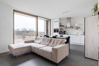 Op zoek naar een plek waar wonen meer betekent dan gewoon thuiskomen? Dit lichtrijke 2-kamer appartement combineert een doordachte indeling, warme materialen en een aangename, moderne sfeer.<br /><br />Dankzij de brede raampartijen geniet je hier van een open en luchtig gevoel, met volop natuurlijk licht doorheen de dag. Het westgericht terras vormt dé ideale plek om te ontspannen na het werk, te genieten van lange zomeravonden of simpelweg weg te dromen bij de ondergaande zon. Bovendien kijk je (binnenkort) uit op het nieuwe park, wat zorgt voor een groen en rustgevend uitzicht vlak bij huis.<br /><br />Als extra troef kan je gebruikmaken van diverse gemeenschappelijke faciliteiten zoals fitness, co-workingruimtes, gezellige lounges en ontmoetingsplekken. Hier woon je niet alleen comfortabel, maar maak je deel uit van een levendige community waar ontmoeten, ontspannen en verbinden centraal staan.<br /><br />Kortom: een stijlvolle en hedendaagse woonplek met licht, groen en comfort als absolute troeven, perfect voor wie modern wonen wil combineren met rust én dynamiek.<br /><br />EPC: 56kWh/m2<br />Momenteel verhuurd, dus ook al investering ideaal!<br /><br />Wg, Gvkr, Gvv, Gmo, Geen overstrominsgevoelig gebied