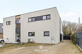 Voor meer info en foto’s, surf naar www.swevers.be – deze recente halfopen bebouwing in de Stationsstraat 85 D in Houthalen-Helchteren combineert ruimte, comfort en energiezuinig wonen op een uitstekende locatie. De woning werd gebouwd in 2019, is volledig instapklaar en afgewerkt met kwalitatieve, neutrale materialen. Met een bewoonbare oppervlakte van 203 m² op een zuidgericht perceel van 1.266 m² geniet u hier van veel licht, een praktische indeling en een aangenaam gevoel van rust. Op het gelijkvloers komt u binnen via de inkomhal met gastentoilet. Verder vindt u een ruime wasplaats, een ruime bureauruimte die ook kan dienen als gelijkvloerse slaapkamer, en een lichtrijke leefruimte van ongeveer 40 m² met zicht op terras en tuin. De open keuken van 14 m² is volledig uitgerust met hoogwaardige toestellen, waaronder een stoomoven, heteluchtoven, koffieapparaat, vaatwasser en inductiekookplaat. Aansluitend zijn er nog een berging en een extra hal met ingemaakte kasten. De verdieping telt nog vier volwaardige slaapkamers van 14 m², 12 m², 10,60 m² en 10,60 m², een extra bergruimte, een badkamer met douche en dubbele lavabo, en een apart toilet. Dankzij de vele praktische bergruimtes is elke vierkante meter optimaal benut. Buiten geniet u van een ruime, zuidgerichte tuin met blijvend groen verzicht achteraan door het aangrenzende agrarische gebied. Extra troeven zijn vloerverwarming, zonnepanelen, warmtepomp, domotica en screens aan de achterzijde. Bovendien wordt er binnenkort een elektrische poort geplaatst. Winkels, scholen, openbaar vervoer en snelwegen bevinden zich vlakbij. Voor meer informatie, bel 011 255 155. Bron bewoonbare oppervlakte: EPC – verslag.
