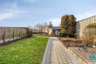 IN OPTIE! Deze verzorgde woning met drie slaapkamers en ruime garage bevindt zich aan de rand van het centrum en werd op energetisch vlak aanzienlijk verbeterd d.m.v. dak- en muurisolatie, beglazing, zonnepanelen en een thuisbatterij.<br /><br />Vanuit de inkomtraphal komt men in de gezellige woonkamer met achterliggende ruime ingerichte keuken met toegang tot de kelder, de aansluitende berging en badkamer met ligbad/douche, wastafelmeubel en toilet.<br />Boven treffen we de overloop met drie slaapkamers en is er via een luik toegang tot de geïsoleerde zolderruimte.<br /><br />De keuken beschikt tevens over een zijingang, dewelke leidt naar de tuin en het zongerichte terras met vrij zicht achteraan, alsook verder toegang verschaft naar de naastgelegen carport en de achterliggende grote garage, die via een naastgelegen servitude toegankelijk is aan de achterzijde. Deze toegangsweg geeft eveneens verder uitzicht over de achterliggende velden en bosrijke omgeving.<br /><br />Specificaties:<br />- EPC: 232 kWh/(m² jaar) / C-label<br />- Geïsoleerde muren en vernieuwd dak<br />- 11 zonnepanelen en thuisbatterij<br />- Airco units boven<br />- Schrijnwerk: PVC (2019)<br />- Asbestveilig