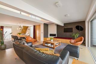 Prachtige moderne woning met praktijkruimten gelegen op een perceel van 1.164 m². Het eigendom omvat op het gelijkvloers een inkomhal met gastentoilet, gezellige leefruimte opgedeeld in eetkamer en salon, een ingerichte keuken, koele berging, masterbedroom met badkamer en dressing, berging, mogelijkheid tot het maken van 3 praktijkruimtes, wachtzaal. Op de verdieping 4 slaapkamers, badkamer, 2 aparte toiletten, grote multifunctionele overloop en technische ruimte. <br />Gezellige tuin met losstaande garage. De garage biedt voldoende plaats voor 2 wagens en berging. Voldoende parkeergelegenheid vooraan de woning.<br /><br />Indeling:<br />Gelijkvloers:<br />Via de inkomhal met gastentoilet heeft u enerzijds toegang tot de leefruimten en anderzijds tot de praktijkruimten (linkerzijde woning). De leefruimte is zeer ruim opgevat: gezellige zitruimte met gashaard en een eetgedeelte. De grote raampartijen bieden een mooie connectie met de gezellige tuin voorzien van ruim overdekt terras achteraan dewelke veel privacy biedt.<br />Aansluitend treft u de volledige ingerichte keuken voorzien van alle comfort. Van hieruit heeft u toegang tot een koele berging. Gelijkvloers is er de masterbedroom met aanpalende badkamer en dressingruimte. Langs de keuken is er een berging met toegang tot de tuin achteraan. <br />Verder bevinden zich op het gelijkvloers 2 praktijkruimten en wachtzaal. Het is voorzien dat de achterste grote praktijkruimte opgesplitst kan worden, zodat er 3 praktijkruimtes zijn. <br />Losstaande dubbele garage met sectionaal poorten.<br />Verdieping:<br />Op de verdieping is er een ruime overloop die momenteel is ingericht als multifunctionele televisieruimte. Verder zijn er 4 ruime slaapkamers, 2 toiletten en badkamer met wastafel en douche. Een van de slaapkamers is momenteel ingericht als fitness, hier is ook de technische ruimte terug te vinden. <br /><br />Bijzonderheden:<br />-Zonnepanelen<br />-Rolluiken en zonnewering bij terras<br />-Airconditioning<br />-Automatisch beregeningsysteem op regenwaterput<br />-CV-installatie op aardgas <br />-Vloerverwarming gelijkvloers<br />- Mogelijkheid tot omvormen van praktijkruimtes naar kangoeroewoning