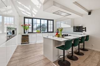 Dit uitzonderlijk duplex appartement is gelegen langs de Turnhoutsebaan in Schilde, een locatie die vlot bereik combineert met een aangename, residentiële omgeving. Op wandel- en fietsafstand bevinden zich buurtwinkels, scholen, openbaar vervoer en diverse horecazaken. Het centrum van Schilde met zijn groene karakter, parken en recreatiemogelijkheden ligt vlakbij, terwijl ook de verbinding naar Antwerpen en Turnhout bijzonder vlot is.<br /><br />Bij het betreden van het appartement komt u binnen via een ruime inkomhal met vestiaire en tegelvloer. Van hieruit leidt de trap naar de leef verdieping, waar een tweede inkomhal toegang geeft tot de verschillende ruimtes. De open leefruimte vormt het hart van het appartement en bestaat uit een ruime eetruimte en een lichtrijke leefruimte met parketvloer en airconditioning. Aansluitend bevindt zich de volledig ingerichte keuken met kookeiland, uitgerust met oven, koelkast, microgolf, diepvries, wijnkoelkast, gasvuur en dubbele spoelbak. De leefverdieping beschikt verder over een aparte bureauruimte met ingemaakte kasten, airconditioning en directe toegang tot het terras, ideaal voor wie wonen en werken wil combineren. Daarnaast zijn er een gastentoilet met handenwasser, een praktische technische berging en een centrale hal met ingemaakte kasten.<br /><br />Op de bovenverdieping bevindt zich een nachthal die toegang geeft tot meerdere slaapkamers. De master bedroom wordt aangevuld met een aansluitende dressing. Daarnaast zijn er nog twee volwaardige slaapkamers, waarvan één met ingemaakte kasten en airconditioning, en een tweede dressingruimte. De stijlvolle badkamer is uitgerust met ligbad, inloopdouche en dubbele wastafel. Verder is er een aparte toiletruimte en een wasplaats.<br /><br />Het zonnige terras vormt een aangename buitenruimte waar het rustig vertoeven is. Tot slot heeft u achter het eigendom op het gelijkvloers een ruime berging voor het stallen van fietsen en de vuilbakken.<br /><br />Een unieke woonopportuniteit voor wie op zoek is naar comfort, ruimte en bereikbaarheid in het hart van Schilde.<br /><br />Troeven:<br />+ EPC A<br />+ Elektriciteit conform<br />+ Zonnepanelen<br />+ Gerenoveerd in 2021<br />+ Aparte inkom<br />+ 4 slaapkamers<br />+ Zeer veel ingemaakte kasten<br />+ Hyper geïnstalleerde keuken<br />+ Centrale locatie<br /><br />Heeft u interesse in dit uniek duplex appartement? Contacteer ons snel op 03 337 50 70 of via info@vbvastgoed.be
