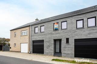 Texte en français ci-dessous / Franstalige tekst onderstaande.<br /><br />NL - Welkom in jouw toekomstige thuis: een bijzonder ruime, lichtrijke en tijdloze nieuwbouwwoning met tuin en inpandige garage. Deze woning biedt alles wat een koppel of gezin nodig heeft voor een comfortabel en modern leven.<br /><br />! KORTING - Bij aankoop van deze woning ontvangt u gedurende 5 jaar een korting van 50% op uw onroerende voorheffing want E-PEIL 16!<br /><br />Bij het betreden van de woning word je verwelkomd door de riante en lichtrijke open leefruimte en keuken (54 m²) met zicht op, en directe toegang tot, de tuin. De grote bergruimte is de ideale plek voor het plaatsen van jouw was- en droogmachine alsook voor opslag. De inpandige garage laat jou toe jouw wagen veilig te parkeren en fietsen te stallen.<br /><br />Op het verdiep beschikt de woning over 3 comfortabele slaapkamers, 2 moderne badkamers en een verder in te richten zolderverdieping die naar eigen wens kan worden benut, bijvoorbeeld als extra slaapkamer, hobbyruimte of home office.<br /><br />De zuidwest georiënteerde tuin zorgt voor een oase van rust en een perfecte plek om te ontspannen of te entertainen.<br /><br />Met de aankoop van deze woning ben je klaar voor de toekomst: Je geniet van comfortabele temperaturen dankzij de PVC– dubbel glas ramen, verwarming via een warmtepomp (lucht/water) met buitenunit en warmtepompboiler, vloerverwarming op alle verdiepen. Daarnaast zijn zonnepanelen geïnstalleerd om te voorzien in duurzame energie, een ventilatiesysteem D zorgt voor gezonde lucht in huis en een videofoon biedt extra veiligheid en gemak. Een gescheiden rioleringsstelsel met septische put en regenwaterput van 10.000 liter zorgen voor efficiënt waterbeheer. De akoestisch ontdubbelde gemene muren met de buren garanderen rust en privacy.<br /><br />De geafficheerde prijs is exclusief isolatie dak / Zonnepanelen (7 stuks) / Tuin nivellering en gras. Indien gewenst kan de woning volledig worden afgewerkt volgens lastenboek bij lokale leveranciers aan 447.000,00 EURO.<br /><br />Deze woning is perfect voor koppels en gezinnen die op zoek zijn naar comfort, duurzaamheid, locatie en modern gemak. Mis deze unieke kans niet en maak van deze prachtige nieuwbouwwoning jouw nieuwe thuis!<br /><br />De aanpalende nieuwbouwwoning wordt ook verkocht via immo Vastima. Alle info op onze website – www.vastima.be.<br /><br />Verkoop onder 21% BTW / Grond 12%. Geafficheerde verkoopprijzen exclusief kosten.<br /><br />FR - Bienvenue dans votre future maison : une maison neuve particulièrement spacieuse, lumineuse et intemporelle, avec jardin et garage intégré. Cette habitation offre tout le nécessaire à un couple ou à une famille pour une vie confortable et moderne.<br /><br />! RÉDUCTION – Lors de l’achat de cette maison, vous bénéficiez pendant 5 ans d’une réduction de 50 % sur le précompte immobilier, grâce à un niveau E de 16 !<br />Dès l’entrée, vous êtes accueilli(e) par un vaste et lumineux espace de vie ouvert avec cuisine (54 m²), offrant une vue sur le jardin et un accès direct à celui-ci. Le grand espace de rangement est idéal pour l’installation d’une machine à laver et d’un sèche-linge, ainsi que pour le stockage. Le garage intégré permet de stationner votre véhicule en toute sécurité et d’y entreposer des vélos.<br /><br />À l’étage, la maison dispose de 3 chambres confortables, de 2 salles de bains modernes et d’un grenier aménageable, pouvant être utilisé selon vos souhaits comme chambre supplémentaire, espace hobby ou bureau à domicile.<br /><br />Le jardin orienté sud-ouest constitue un véritable havre de paix et un endroit idéal pour se détendre ou recevoir.<br /><br />Avec l’achat de cette maison, vous êtes prêt(e) pour l’avenir : vous profitez de températures agréables grâce aux châssis en PVC avec double vitrage, d’un chauffage par pompe à chaleur (air/eau) avec unité extérieure et boiler thermodynamique, ainsi que d’un chauffage par le sol à tous les niveaux. Des panneaux photovoltaïques assurent une production d’énergie durable, un système de ventilation D garantit un air intérieur sain et un vidéophone offre sécurité et confort supplémentaires. Le système d’égouttage séparé, combiné à une fosse septique et une citerne d’eau de pluie de 10.000 litres, permet une gestion efficace de l’eau. Les murs mitoyens acoustiquement doublés avec les voisins garantissent calme et intimité.<br /><br />Le prix affiché n’inclut pas : l’isolation du toit / les panneaux solaires (7 unités) / le nivellement du jardin et l’ensemencement du gazon.<br /><br />Si souhaité, la maison peut être entièrement achevée selon le cahier des charges, auprès de fournisseurs locaux, pour un prix de 447.000,00 EUR.<br /><br />Cette maison est idéale pour les couples et les familles à la recherche de confort, de durabilité, d’un bon emplacement et de commodités modernes. Ne manquez pas cette opportunité unique et faites de cette superbe maison neuve votre nouveau chez-vous ! La maison neuve attenante est également proposée à la vente par Immo Vastima.<br /><br />Toutes les informations sont disponibles sur notre site web – www.vastima.be. <br /><br />Vente soumise à la TVA de 21 % / Terrain à 12 %. Prix de vente affichés hors frais.<br />