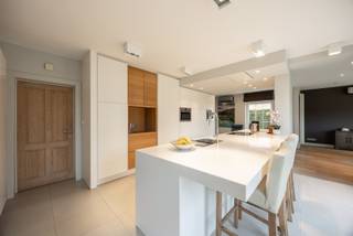 Prachtige ruime villa met naastliggende bouwgrond!<br /><br />Troeven:<br />- Villa op 10a29ca <br />- Bouwgrond 10a50ca met poolhouse en zwembad<br />- Volledig instapklaar <br />- Energielabel A!<br /><br />Deze prachtige ruime villa (goed voor 327m² woonoppervlakte), gelegen op 10a29ca met aangrenzend 10a50ca bouwgrond (met poolhouse en zwembad) wordt verkocht in zijn geheel.<br /><br />Eenmaal we de woning betreden, merken we direct hoeveel ruimte en comfort hier aanwezig is. Vanuit de inkomhal, is er toegang tot de bureau/slaapkamer gelijkvloers. Deze ruime kamer is voorzien van een volledig ingebouwde kastenwand. Verder kunnen we vanuit de inkomhal naar het verdiep alsook de leefruimte. In de leefruimte valt de speelsheid met ruimtes en de grote hoeveelheid lichtinval zeer hard op.<br /><br />De leefruimte (voorzien van 2 airco's in 2021) is één geheel, samen met de vernieuwde aanbouw en keuken. In de leefruimte, de hal en het kantoor ligt marmer, terwijl in de keuken er een prachtige tegelvloer aanwezig is en de aanbouw voorzien werd van parket. De keuken is high-end en compleet afgewerkt. Zo is er een gewone oven, een stoomoven, een combi-oven, een nieuwe vaatwasser, een inductievuur (5-pits) en een ruime koelkast. Verder is er een eiland en een hoge kastenwand voorzien van elektronische lades en genoeg stopcontacten. Het eiland heeft een Corian-werkblad. Achter de keuken vinden we nog een koele berging voor extra voorraad te stockeren. <br /><br />Verder vinden we gelijkvloers nog een apart toilet met wastafel, alsook een zeer ruime wasplaats voorzien van inloopdouche, wastafel en zeer veel ingebouwde kasten.<br /><br />Op verdiep vinden we vervolgens 4 grote slaapkamers en een zeer ruime badkamer terug. Op de overloop hangt opnieuw een airco van 2021, alsook in de master bedroom werd dit voorzien. De badkamer is voorzien van een bad, douche, toilet en een zeer ruim badmeubel. Deze ruimte werd volledig betegeld.<br /><br />Via een vlizotrap heeft men toegang tot de zolder, die absoluut nog de mogelijkheid biedt om extra woonruimte te creëren. <br /><br />Deze ruime woning wordt verwarmd aan de hand van luchtluchtwarmtepompen en een condenserende gasketel van 2014. De EPC-score bedraagt 84, wat een fantastisch resultaat is want gelijk staat aan een A-label. Ook is er in totaal voor 15.220 WP aan zonnepanelen voorzien. Tevens zorgt de elektrische home manager dat het huis klaar is voor optimalisatie van het stroomverbruik. Hij maximaliseert het eigenverbruik door toestellen, opslagsystemen, warmtepompen en laadstations voor elektrische voertuigen aan te sturen op basis van verbruiksprofielen en weersvoorspellingen.<br /><br />Buiten vinden we een ruime inrit die tot achter gaat naar de zeer ruime garage. De garage is voorzien van een sectionale poort en er werd een laapaal aan toegevoegd. Hier is nog een bergzolder, zodanig dat er voldoende stockageruimte is. 2. Naast de garage vinden we een overkapping terug, waardoor 2 auto's perfect droog kunnen staan en er is ook een laadpaal voor elektrische wagens.<br />Vervolgens vinden we dan nog een extra bergruimte terug, waar de installatie van het zwembad zich ook in bevindt.<br /><br />Het ruime ingebouwde zwembad is voorzien van een nieuw polycarbonaat roldeck, waardoor het veel sneller opwarmt en langer warm blijft. Uiteraard is er ook een zwembadinstallatie om het zwembad te onderhouden en te verwarmen. Naast het zwembad staat een prachtig poolhouse. Dit poolhouse is voorzien van een gaskachel, heeft veel charme door de aanwezige eiken balken en een natuurstenen vloer. Het is voorzien van een bar met koelkast, wat het heerlijk vertoeven maakt hier.<br />Ook is er nog een pergola aanwezig met diverse stopcontacten en krachtstroom.<br /><br />Dit geheel, ligt op een perceel van 20a79ca, maar bestaat eigenlijk uit twee bouwkavels. Hierdoor is er een mogelijkheid om (op latere termijn) nog een woning te plaatsen voor het zwembad en poolhouse.<br /><br />Heb jij interesse of vragen over dit prachtige geheel?<br />Contacteer ons op 011 55 64 00 of info@vastgoedfransen.be.
