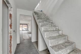 <p>Voor meer info of een bezoek, bel 053 59 49 34 - Op een gunstige locatie te Ternat bevindt zich deze <strong>nieuwbouwwoning</strong>. Verschillende faciliteiten (scholen, openbaar vervoer, winkels, centrum Ternat, ..) bevinden zich in de nabije omgeving. De E40 richting Brussel en Gent is vlot bereikbaar. <strong>De woning wordt volledig afgewerkt, exclusief de aanleg van de tuin</strong>. Binnenkomen doen we in de inkomhal waar zich de gastentoilet bevindt. Verder vinden we op het gelijkvloers een gezellige woonkamer met aansluitend de keuken en <strong>de inpandige garage</strong>. Het eerste verdiep telt <strong>twee slaapkamers</strong> en een badkamer. <strong>De zolder</strong> is toegankelijk met een vaste trap en kan dienst doen als derde slaapkamer. <strong>De woning wordt in totaliteit verkocht onder 21% BTW.</strong></p>