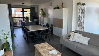 Ruim en lichtrijk appartement in hartje Arendonk<br /><br />In dit appartement op de bovenste verdieping van een unit met 5 appartementen heb je een weids uitzicht over de “skyline” van Arendonk. Doordat het appartement aan het uiteinde van het gebouw ligt, en er geen appartementen/hogere gebouwen tegenover gelegen zijn, heb je geen inkijk maar wel een open zicht op de omgeving.<br /><br />Vanuit de inkomhal met gastentoilet kom je binnen in de keuken, uitgerust met een combi-oven, elektrische kookplaat en vaatwasser, en een groot keukeneiland waaraan je gezellig kunt aperitieven. Aanpalend aan de keuken vind je de berging waar je de wasmachine, droogkast en voorraad kwijt kunt. Op deze keuken geeft een groot terras van 20m² uit waarop je 's ochtends in het zonnetje kunt ontbijten, en waar het 's avonds na een warme zomerdag nog goed toeven is. Dit terras verloopt aan de achterzijde over de volledige breedte van het appartement.<br /><br />In de ruime en lichtrijke living is er plaats voor een grote eettafel, gezellige zithoek én een bureau. Via een gang die aan het tweede terras (12m², westelijk georiënteerd) grenst, kom je in de nachthal waar je de badkamer met dubbele lavabo, douche en tweede toilet vindt, en 2 slaapkamers. Alle ruimtes zijn voorzien van vliegenramen.<br /><br />Onder het gebouw bevinden zich tevens een berging en 1 ruime parkeerplaats, die inbegrepen zijn. Je fiets kan je stallen in de gemeenschappelijke fietsenkamer op het gelijkvloers. <br /><br />Troeven van dit appartement:<br />- open zicht en privacy<br />- 2 grote terrassen<br />- Hoge plafonds en veel lichtinval door de hoge ramen rondom in de leefruimte. Laat je niet misleiden door het schuine dak op de foto; door een slimme indeling van het appartement is er enkel in de badkamer (boven het toilet) en in één van de slaapkamers (in de slaaphoek) een schuin plafond<br />- Op wandelafstand van het centrum van Arendonk, maar toch rustig gelegen<br />- EPC A<br />- recent gebouw <br />- 4 zonnepanelen uitbreidbaar