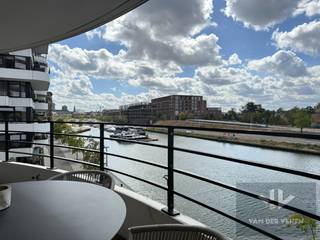 <u><strong>Prachtig hoekappartement in Zuidzicht, vlak aan het water met 3 slpk, 2 badk en terras met waterzicht!</strong></u><br /><br /><u>Welkom in Zuidzicht II</u><br />Zuidzicht II bevindt zich langs de Kempische Kaai (Scheepvaartlaan) in Hasselt, aan de jachthaven aan de zogenaamde Blauwe Boulevard. Deze zone combineert water, ontspanning en stedelijke faciliteiten tot een aantrekkingspool in de stad. <br />Het wooncomplex is ontworpen met ‘belevingsarchitectuur’ als leidraad: duidelijke relatie met het water, gelaagde terrassen die doen denken aan een majestueus cruiseschip, gevelhoge ramen die uitzicht maximaliseren én het gevoel van ruimte en verbinding met buiten bevorderen.<br /><br /><strong><u>Troeven:</u></strong>
<ul>
	<li>Topligging aan het water: direct aan de jachthaven van Hasselt (Blauwe Boulevard).</li>
	<li>Belevingsarchitectuur: terrassen in cruiseschipstijl, gevelhoge ramen, sterke connectie binnen-buiten.</li>
	<li>Tegenover Quartier Bleu: modern, groen en luxueus woonmilieu.</li>
	<li>Centrale ligging: wandelafstand van centrum, winkels, horeca, openbaar vervoer en vlotte verbinding naar E313/E314.</li>
	<li>Stijlvol hoekappartement: veel licht en ruimtelijk gevoel.</li>
	<li>3 slaapkamers en 2 badkamers: inclusief een ensuite badkamer.</li>
	<li>Luxueuze afwerking: parketvloeren, keukeneiland, hoogwaardige materialen.</li>
	<li>Terras met waterzicht: blijvende connectie met het water vanuit de leefruimte.</li>
	<li>Ruime oppervlakte: extra gevoel van ruimte en comfort.</li>
	<li>Kelderberging inbegrepen: praktische stockage.</li>
	<li>Mogelijkheid tot aankoop van 2 parkeerplaatsen (€35.000/stuk).</li>
</ul>
<br /><u>Ligging en verbinding met Quartier Bleu</u><br />Direct tegenover Zuidzicht ligt Quartier Bleu: een moderne woonwijk met stijlvolle appartementen, veel groen, luxe afwerking en eveneens ligging aan het water in de jachthaven. De buurt is ontworpen als één groot, verfijnd woonmilieu in het stadscentrum. <br />Zuidzicht II is tevens ook zeer centraal gelegen: op wandelafstand van het bruisende centrum van Hasselt, winkels, horeca, openbaar vervoer en belangrijke verkeersaders zoals de snelwegen E313/E314.<br /><br />Een ware opportuniteit is dit prachtig gelegen en high-eind afgewerkt appartement met maar liefst 3 slaapkamers, 2 badkamers en een terras met uitzicht op het water.<br /><br />Dit stijlvolle hoekappartement is gelegen op de tweede verdieping, zodat u vanuit de leefruimte connectie behoudt met het water. Het werd luxueus afgewerkt met parketvloeren, keukeneiland, en maar liefst 3 slaapkamers waarvan 1 ensuite badkamer. <br /><br />De riante oppervlakte garandeert u een ruimtelijk gevoel, stockage kan in de inbegrepen kelderberging. Er zijn twee parkeerplaatsen mogelijk om aan te kopen aan €35.000,00 per parkeerplaats.<br /><br />Grijpt u deze ware opportuniteit om in één van Zuidzichts mooiste appartementen te wonen? <br /><br />Laat je gegevens achter onder dit zoekertje en René leidt je graag rond in deze parel!<br /><br />Tot snel, aan het water!
