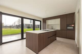 <p><span>Aan de rand van Wespelaar-dorp ligt deze nagelnieuwe open bebouwing (BEN-woning) met 4 kamers, een volledig aangelegde tuin, inclusief haagbeuk, grassen, opritten, terras en zwarte draadafsluiting. Rust en een groen uitzicht, worden hier gekoppeld aan een hedendaags uitzicht met gelijmde betonstenen, witte sierpleister en zwarte alu-ramen, plus een carport met geïntegreerde verlichting. In de ruime inkom valt, naast de ingemaakte kasten, de betontrap op, die is bekleed met dezelfde tegels als het gelijkvloers. De leefruimte met open keuken (eiland) is in L-vorm voorzien, zodat de tuin van overal goed zichtbaar is, door de kamerbrede schuiframen. De greeploze keuken met betonlook werkblad, omvat volgende apparaten: kookplaat met geïntegreerde afzuiging, oven, koelkast en freezer. Afgezien van de technische berging met warmtepomp en ventilatie D, ligt naast de keuken nog een handige wasplaats. In de badkamer is plaats voor een dubbel meubel met zwarte accenten en houten fronten; kolomkasten; een inloopdouche met glazen wand, nis en regendouche; plus een ligbad. De hangtoiletten met handwasbakje werden apart ondergebracht. De Bijna Energieneutrale Woning beschikt over algemene vloerverwarming, dikke isolatielagen (vloer, muur en dak), plus 9 zonnepanelen. Let op de goede plafondhoogte en de kwalitatieve binnendeuren met verborgen scharnieren.</span></p><p><span> </span></p>