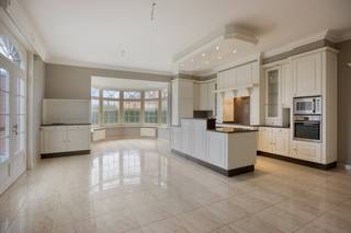 Aan de Kraaistraat 9B in Geetbets vinden we deze imposante Franse villa terug, gebouwd in 2006 met kwalitatieve materialen en een tijdloze architectuur die vandaag de dag nog altijd indruk maakt. De woning is zuidelijk georiënteerd, waardoor de tuin het hele jaar door optimaal van de zon geniet. Een ruime, groene buitenruimte die uitnodigt om te ontspannen of voor de professionele gebruiker, als aangename omgeving voor patiënten en bezoekers.<br /><br />Wie binnenstapt, wordt meteen getroffen door de kwaliteit en de schaal van dit pand. De inkomhal van 17m² zet meteen de toon: representatief, rustig en ruim genoeg om als professionele ontvangst- of wachtruimte in te richten, een troef die in de zorgsector of bij een vrij beroep zelden zo vanzelfsprekend aanwezig is. Aansluitend bevindt zich een uitzonderlijke leefruimte van 60m², die alle kanten opgaat: een royale gezinsruimte, een ruimte voor groepsconsultaties of therapiesessies, een representatieve vergader- of ontvangstruimte, de indeling bepaalt u zelf. De zeer ruime keuken met bijkeuken, de slaapkamer en de volwaardige badkamer op het gelijkvloers completeren een niveau dat perfect autonoom kan functioneren, volledig los van de verdieping.<br /><br />Op de eerste verdieping bevinden zich vijf volledig afgewerkte kamers, elk veelzijdig inzetbaar als slaapkamer, bureau, praktijkruimte of behandelkamer. Eén van de kamers is voorzien van leidingen voor een tweede badkamer. Wat dit niveau werkelijk onderscheidt, is de toegankelijkheid: via een vaste trap vanuit de garage is de verdieping volledig onafhankelijk bereikbaar, zonder enige doorgang over het gelijkvloers. Twee gescheiden ingangen, twee volledig autonome niveaus: de basis voor een dubbele wooneenheid, een praktijk met privéwoning of een groepspraktijk met aparte woonst ligt hier klaar, mits de nodige vergunningen. Aanvullend zijn er nog twee ruime bergzolders, eveneens voorzien van elektriciteit en een betonnen chape, ideaal als technische ruimte, archief of opslag. De woning is bovendien volledig onderkelderd met een kruipkelder over de gehele footprint. Gebouwd in 2006 betekent: geen asbestproblematiek, een degelijke constructie en een EPC-label C dat realistisch en beheersbaar is.<br /><br />Dit pand opent ook een piste die steeds meer families bewust overwegen: de kangoeroe-woning. Ouders en kinderen verkopen elk hun huidige woning, bundelen de opbrengst en stappen samen in één aankoop, maar wonen volledig onafhankelijk van elkaar. Gelijkvloers voor de ene generatie, eerste verdieping met eigen ingang voor de andere. Elke entiteit heeft zijn eigen leefruimte, keuken, badkamer en toegang. Geen compromis op privacy, wel de nabijheid die een zorgzame familieband verdient. Wie twee afzonderlijke woningen op de huidige markt wil kopen voor dit totaalbudget, zal snel merken dat €599.000 voor dit volume en deze kwaliteit een uitzonderlijke opportuniteit is die zich niet twee keer aandient.<br /><br />Of u nu droomt van een woon-werkvilla, een praktijk met privéwoning, een kangoeroe-formule of een investering in twee autonome entiteiten. Dit pand biedt de schaal, de infrastructuur en de flexibiliteit om elk van die verhalen waar te maken. Nieuwbouw met deze kwaliteit en dit volume realiseren voor €599.000 is vandaag simpelweg niet meer mogelijk.