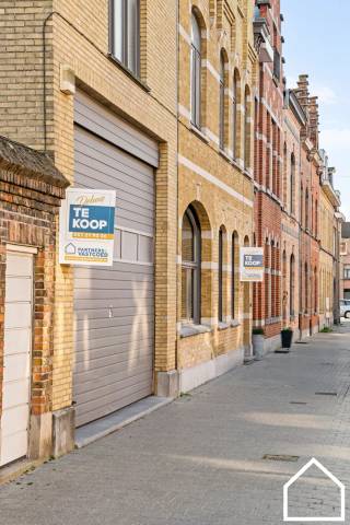 In het centrum van Ieper bevindt zich deze ruime en statige herenwoning met tal van mogelijkheden en prachtig bewaarde authentieke elementen.<br />Bekijk zeker onze vastgoedvideo via deze link: https://youtube.com/shorts/gDVhlAI51ag<br />Via de royale inkomhal met open traphal en toegang tot de kelder kom je in de elegante L-vormige leefruimte (47,50m²) met massief visgraatparket en karaktervolle ornamenten. Aansluitend vind je een recente veranda (2020) met zonnewering — een ideale extra leefruimte met zicht op de tuin. De moderne, volledig ingerichte keuken (24m²) beschikt over een gezellige ontbijthoek.
Op het gelijkvloers is er bovendien een lichtrijke polyvalente ruimte (76,8 m²), voormalige artsenpraktijk van met afzonderlijk toilet — perfect als praktijk, kantoor of hobbyruimte. Via de wasberging bereik je de ruime garage (45m²) met automatische grote poort.<br />De aangelegde, zuidgerichte tuin vormt een heerlijke buitenruimte om in alle rust te genieten.<br />Op het tussenverdiep bevindt zich een dressing (13m²) en een eerste badkamer (5m²) met ligbad, lavabo en 2de wc. De eerste verdieping telt drie ruime slaapkamers (17m² - 10m² - 21m²), een tweede badkamer (11m²) met ligbad, douche, dub lavabo en 3de toilet. Aansluitend een lichtrijke verder in te richten hobby-/ atelier ruimte (67m²). De tweede verdieping beschikt over nog twee volwaardige slaapkamers ( 56m² - 15m²) en via het zolderluik bereik je de bergzolder (70m²).<br />Extra troeven:
•	Veel indelings- en gebruiksmogelijkheden
•	Authentieke elementen prachtig bewaard
•	Ruime garage met bovenliggende hobbyruimte
•	EPC-label C
•	Centrale en vlot bereikbare ligging
•	Ideaal voor combinatie wonen/werken<br />Kortom: een uitzonderlijke eigendom met karakter, ruimte en potentieel.<br />