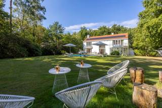 <p>Zoekt u het ultieme vakantiegevoel zonder uw huis te verlaten? Dan is deze villa de perfecte woning voor u. Deze luxe, moderne en zeer lichte villa bevindt zich in de groene, residentiële Bellemond wijk op een toplocatie te ’s Gravenwezel. Hier geniet u van volledige privacy in een prachtige zuidwest-georiënteerde tuin met een verwarmd zwembad. De villa is ideaal gelegen nabij scholen, openbaar vervoer en winkels, en ligt in een van de meest prestigieuze wijken van ’s Gravenwezel.</p>
<p>Deze architectenwoning, ontworpen door de gerenommeerde architect John Bontinck, is gebouwd met hoogwaardige materialen. De visie van de architect om de tuin sterk bij de woning te betrekken, is werkelijk verbluffend geslaagd. Bij binnenkomst wordt u meteen gecharmeerd door het vakantiegevoel dat de villa uitstraalt. Een prachtige doorkijk naar de tuin en het zwembad verwelkomt u direct.<br /><br />INDELING<br /><br /><strong>Gelijkvloers:<br /></strong>Bij binnenkomst wordt u meteen gecharmeerd door het vakantiegevoel dat de villa uitstraalt. Een prachtige doorkijk naar de tuin en het zwembad verwelkomt u direct. <br />U treedt de villa binnen via een inkomhal met een apart gastentoilet en een ruime vestiaire. Een dubbele glazen deur biedt toegang tot de riante en lichte woonkamer met een doorlopend raam tot de verdieping. De leefruimte, verdeeld in zithoek, salon en eetkamer, is voorzien van een eiken parketvloer en een prachtig open haard. De ruimtes vloeien mooi in elkaar over en zijn in direct contact via grote deurramen met het zuidwest-georiënteerde terras, de tuin en het zwembad.<br /><br />Aansluitend aan de leefruimte vindt u de volledig geïnstalleerde keuken met een kookeiland, ontbijthoek, tal van opbergkasten en moderne toestellen, waaronder een Amerikaanse koelkast. Door kamerhoge raampartijen rondom de keuken wordt deze ruimte overspoeld met natuurlijk licht en biedt het een prachtig uitzicht op de tuin en het zwembad.<br /><br />Een praktische douchekamer met toegang naar buiten is ideaal na een zwembeurt in het zwembad.<br /><br />Een mooie houten trap leidt naar de eerste verdieping, waar een impressionante vide extra licht en uitzicht biedt vanuit de verdieping op de prachtige tuin.<br /><br /><strong>1e Verdieping:<br /></strong>Op de 1e verdieping vindt u de mastersuite met dressing en badkamer – met ligbad, dubbele lavabo en toilet. De 2e slaapkamer (ca. 31m²) op parket met ingemaakte kasten geeft uit op een prachtig terras. De 2e (ca. 20m²) en 4e slaapkamers (ca. 18m²) delen de 2e badkamer met ligbad, lavabo en toilet. Verder is er nog een handige berging, ideaal voor een linnenkast of een extra douchekamer.<br /><br /><strong>Tuin en Zwembad<br /></strong>Geniet volop van de zonnige tuin in volledige privacy zonder enige inkijk. De tuin is aangelegd met verschillende terrassen, een verwarmd zwembad en een tuinhuis. Deze buitenruimte biedt de perfecte setting voor ontspanning, zomerse barbecues en gezellige avonden.<br /><br />Een inpandige garage biedt ruimte voor 2 wagens en heeft een automatische toegangspoort. Daarnaast is er een ruime oprit met plaats voor meerdere wagens, wat extra gemak en parkeerruimte biedt voor u en uw gasten.<br /><br />Kortom, deze villa is een waar paradijs voor wie houdt van een luxe levensstijl met een vleugje vakantie. De ruime indeling en grote ramen zorgen voor een lichte en luchtige sfeer. Mis deze unieke kans niet om in een van de meest gewilde wijken van ’s Gravenwezel te wonen.</p>
<p></p>
<p>BIJZONDERHEDEN:<br />+ Architect John Bontinck<br />+ Nieuw gietvloeren op verschillende ruimtes<br />+ Vloerverwarming <br />+ 15 zonnepanelen (2024)<br />+ Gunstig EPC: 164kWh/m²<br />+ Vloerverwarming op GLV<br />+ Asbestvrij.<br />+ Bose audio-installatie in alle ruimtes, voor optimale geluidservaring.<br /><br />Voor meer informatie of een bezoek aan deze gezellige woning, neem gerust contact op met Sigalit via Sigalit@reds.be of op 0475668474</p>