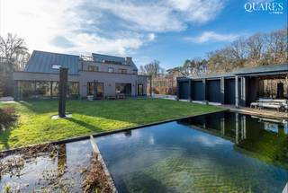 <p><strong>Quares - TREVI Groep presenteert :<br /></strong></p>
<p>Quares by Trevi presenteert: Vakantiegevoel &amp; privacy in droomwoning in doodlopende straat Geïnspireerd op de stijl van Piet Boon, wordt deze knappe villa gekenmerkt door architecturale elementen, technisch hoogstaande snufjes en één constante: kwaliteit. Dit vertaalt zich in hoogwaardige materialen, geplaatst en afgewerkt door de beste experts in hun vakgebied. Tijdloos design, mooie zichtlijnen door het hele huis, enorm veel lichtinval, en opvallend veel focus op rust en ontspanning, maken dat je hier echt kan binnenstappen, het werk achter je laten, en genieten van al het heerlijks dat binnen &amp; buiten te bieden heeft: open haarden, binnenzwembad, home cinema, verschillende dakterrassen, zwemvijver &amp; poolhouse, prachtig aangelegde tuin met boszicht, meerdere terrassen… Alle stress valt weg en een gevoel van harmonie, rust en balans neemt over als je hier kan vertoeven. Zowel het gebruik van hoogwaardige materialen zoals corian (keuken, badkamers), volle eik (dressings, parketten, kamerhoge deuren) en notenhout (keuken), zinken dak, domotica, zonnegascombi, warmtepompen, airco, videofonie, camera’s, zonnewering, en uitzonderlijke gadgets zoals je vingerafdruk als sleutel, en onzichtbare elementen (drainage, onderparket, isolatie, hoogrendement ++ beglazing,…) bewijzen de topkwaliteit van deze woning. <br /><br />INDELING: <br /><br />GLVL: Inkomhal; wasplaats &amp; vestiaire; gastentoilet; royale leefruimte met open haard en prachtig zicht op de tuin; bureau aan de voorzijde; home cinema of eetkamer; inpandig terras op het westen om te genieten van de avondzon, met grote ramen en open haard waardoor buiten binnen wordt en omgekeerd; ruime keuken met eiland en ontbijthoek, veel kastruimte, Gaggenau toestellen, teppanyaki plaat en breed gasvuur met professionele Venduro dampkap, wijnkoeler en Amerikaanse koelkast, Quooker kraan; en dan een enorme &amp; lichte ruimte waar het heerlijke binnenzwembad met ionisatie &amp; jetstream terug tot zijn recht kan komen (alles werkt nog steeds perfect!), of zoals nu netjes verstopt en dienst doend als extra relax &amp; chillruimte; badkamer met vrijstaand bad en dubbele lavabo, douche, toilet. <br /><br />KELDER: Indrukwekkend ruime &amp; droge kelder die als nieuw afgewerkt is met 6 (!) ruimtes met actieve ventilatie voor mancave, speelruimtes, opbergruimte, wijnkelder, fitnessruimte etc, met technische ruimte voor het binnenzwembad en technische berging met nutsvoorzieningen etc. <br /><br />EERSTE VERD: Op deze verdieping bevinden zich 5 slaapkamers: Dressing; master bedroom met en suite dressing en privé dakterras; 3 ‘normale’ slaapkamers waarvan 1 met privé-terras; 1 gigantische slaapkamer boven het binnenzwembad; ruime badkamer met ligbad, douche, bidet, 2 aparte lavabo’s en privé-terras; apart toilet. <br /><br />TWEEDE VERD: Zesde slaapkamer of hobbyruimte/aparte studio, … met toegang tot een heerlijk groot dakterras achteraan en een gezellig ingesloten terras vooraan. Troef: alle slaapkamers hebben massieve parket en airco. <br /><br />BUITEN: Automatische poort, perceel volledig omheind met leilindes en hagen, oprit met 3 tot 4 parkingplaatsen binnen de omheining en extra buiten, overdekte berging, oprijlaan naar garage. Poolhouse met douche, lavabo, toilet, overdekt terras met infrarood verwarming, opbergruimte. Zwemvijver met lavabad en circulatiepomp. Verzorgde tuin met verschillende terrassen en origineel, knap tuinhuis gebouwd rond een prachtige boom. <br /><br />LIGGING: De woning bevindt zich op een unieke locatie in een doodlopende straat, uitkijkend op een beschermd natuurgebied, vlak aan de Golf van Keerbergen. Geïntrigeerd door deze indrukwekkende eigendom? Maak dan graag je afspraak voor een uitgebreide rondleiding met Tinne Schotsmans op 0477 60 21 99 of tinne.schotsmans@quares-trevi.be</p>