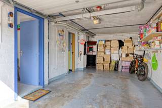 Solide bel-etagewoning van 1968 met een totale bruikbare oppervlakte van 174m, gebouwd op een perceel van 1a95ca in een rustige wijk met achteraan zicht op de velden. Op de gelijkvloerse verdieping vindt u de inkomhal met aparte wc, een garage voor 1 wagen + 2 staanplaatsen voor het huis, stookplaats, badkamer en 2 opbergruimtes. Op de eerste verdieping vindt u de leefruimte (29m²) met rechtstreekse toegang tot een veranda en de tuin en een ingerichte keuken. De tweede verdieping bestaat uit 2 slaapkamers (17m² en 11m²) en een badkamer met ligbad, wc en 1 lavabo. Er is vaste trap naar een grote zolderkamer (29m²) die mogelijks nog kan opgesplitst worden in 2 slaapkamers. Er is overal dubbele beglazing (PVC) en de woning verwarmd met een condenserende gasketel. Uitstekende EPC-score B!