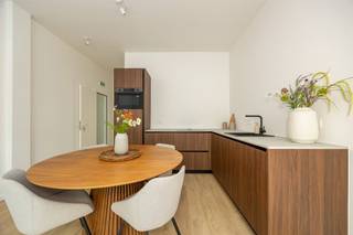 <p><span>Helemaal instapklaar, strak gerenoveerd én een eigen tuintje? Dit gelijkvloerse appartement combineert een warme afwerking met twee slaapkamers, een knappe keuken, trendy badkamer en sterke energiescores. Je woont bovendien in een fijne hoek van Berchem, met het Brilschanspark, natuurgebied Wolvenberg en sportcentrum Het Rooi vlakbij.</span><span> </span></p><p><span> </span></p><p><span>Warm hout &amp; strakke lijnen</span></p><p><span>Je komt binnen in een lichtrijke leefruimte, waar de warme parketlaminaat meteen mooi contrasteert met de strakke witte muren en zwarte raamprofielen. Er is voldoende plaats voor een gezellige zithoek en een eettafel, met aan de andere kant de open keuken.  Die is een echte blikvanger, met donkerbruine houtlook fronten, een strak werkblad en trendy kraanwerk. Ook qua toestellen zit je goed: Samsung combioven en vaatwasser en een Elica inductievuur met ingebouwde afzuiging. De zwarte pvc-ramen met driedubbele beglazing zorgen voor veel natuurlijk licht én extra comfort. Vanuit de leefruimte wandel je via de overloop naar de rest van het appartement. De mooie houtlook vloer loopt hier gewoon door, waardoor het geheel rustig en uniform aanvoelt. Handig is de aparte berging met aansluiting voor je wasmachine, de elektrische boiler en de omvormer van de privatieve zonnepanelen.</span></p><p><span> </span></p><p><span>Twee slaapkamers &amp; een frisse badkamer</span></p><p><span>Je hebt hier twee slaapkamers allebei met dezelfde warme vloer en grote ramen met driedubbele beglazing. De grootste slaapkamer geeft rechtstreeks uit op de tuin: ’s morgens de deur openzetten en meteen wat frisse lucht binnen, zalig.  Ook de badkamer werd helemaal in dezelfde hedendaagse stijl afgewerkt. Je hebt er een inloopdouche met grijze tegel, regendouche, een houtlook badkamermeubel met witte opbouwwastafel en donker geborsteld kraanwerk. </span></p><p><span> </span></p><p><span>Een eigen stukje groen</span></p><p><span>Een appartement én een eigen tuin: altijd een fijne combinatie. Achteraan krijg je een charmant terras , compact en onderhoudsvriendelijk, maar groot genoeg om buiten te ontbijten, wat groen te zetten of na het werk nog even van de buitenlucht te genieten.</span></p><p><span>Ook technisch zit dit appartement goed in elkaar. Met een EPC A, privatieve zonnepanelen, driedubbele beglazing, ventilatiesysteem C+, conforme elektriciteit en een asbestveilig attest is er stevig ingezet op energiezuinig en comfortabel wonen. </span></p><p><span> </span></p><p><span>Groen wonen in Berchem</span></p><p><span>Hier woon je rustig en groen, zonder ver van de stad te zitten. Het Brilschanspark en natuurgebied Wolvenberg liggen op wandelafstand, net als sportcentrum Het Rooi. Voor je dagelijkse boodschappen vind je verschillende supermarkten enkele straten verder. Zin in winkels, een koffietje of iets lekkers? Dan ben je zo in Oud-Berchem, de Pulhofwijk of Groenenhoek. </span></p><p><span> </span></p>