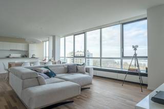 Instapklaar en gemeubeld appartement (125m²) op de 19de verdieping van Residentie 'Panorama Tower'! Op deze hoogte heeft u een uniek zicht op de haven van Antwerpen, de Schelde en het Sint-Annabos. Het appartement is ingedeeld als volgt : inkomhal met ingemaakte vestiairekast; woonkamer (58m²) op parketvloer met open ingerichte keuken op tegelvloer met kasten en toestellen (o.a. gasvuur, microgolf, oven, dampkap, vaatwasser, koelkast, diepvries en ontbijthoek); bergruimte met wasmachine en droogkast (inbegrepen); 2 slaapkamers (22,5m² en 9m²) waarvan de grote slaapkamer een aansluitende dressing heeft; nachthal met apart toilet; badkamer met ligbad, douche en lavabomeubel; terras, kelder en autostaanplaats! Gemeenschappelijke fietsenberging! Zeer rustig gelegen en toch op wandelafstand van winkels en openbaar vervoer! Algemene onkosten bedragen 300 euro / maand (INCLUSIEF provisie CV, privatief waterverbruik, huisvuilophaling, conciërge, lift, poetsen gemene delen)! Beschikbaar vanaf 01 september 2026. EPC: 213 kWh/m²