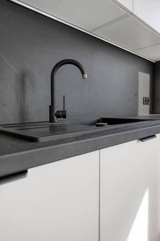Welkom in de Raf Verhulstlaan 36-38, waar Immotrix met trots twee nieuw gerenoveerde appartementen op de tweede verdieping (ca. 100 m²) presenteert. Dit project overstijgt de standaard renovatie; het betreft een compromisloze, totale heropbouw met diep respect voor esthetiek, duurzaamheid en technische perfectie.
Vanaf de fundering tot de afwerking is werkelijk alles vernieuwd. Alle leidingen en de volledige elektriciteit zijn up-to-date en conform de strengste normen geplaatst. Dankzij een doorgedreven, hoogwaardige isolatiestrategie genieten deze appartementen van een zeldzaam en toekomstgericht EPC B-label — uw garantie op een zorgeloze en energiezuinige toekomst.
Bij het betreden van het appartement valt direct de indrukwekkende lichtinval op. De royale raampartijen aan de voorzijde laten het daglicht vloeiend weerspiegelen op de strakke vloerafwerking. De leefruimte loopt naadloos over in een hypermoderne leefkeuken. Deze blikvanger is uitgerust met een monumentaal kookeiland in een verfijnde, donkere natuursteenlook en afgewerkt met greeploze, gelaagde witte fronten en premium matzwarte kranen en details.
De badkamer ademt de sfeer van een high-end boetiekhotel. Dankzij de warme tonen het design-maatwerk, kamerhoge keramische tegels in een zachte zandkleur en een luxueuze inloopdouche met een minimalistische glazen wand, geniet u hier dagelijks van puur wellnesscomfort.
Het nachtgedeelte is doordacht ingedeeld en beschikt over twee volwaardige, rustgevende slaapkamers waarvan 1 met toegang naar het zonovergoten terras. Daarnaast herbergen deze appartementen een architecturaal geheim: een ruime, multifunctionele flex-room. Hoewel deze kamer bewust zonder buitenraam is ontworpen om een intieme en serene sfeer te waarborgen, biedt de ruimte een ongeziene flexibiliteit. Door de perfecte visuele en akoestische afzondering leent deze kamer zich uitstekend als een exclusieve walk-in dressing, een inspirerende en stille thuiswerkplek (home office), of een geborgen, fluisterstille babykamer. Een appartement op de 2de verdieping is momenteel verhuurd aan 1.175 € per maand wat dit object ook tot een interessante investeringsopportuniteit maakt.
Wonen in Wommelgem betekent hier: intrekken zonder toegevingen, omringd door tijdloze esthetiek, modern comfort en een ongeëvenaard afwerkingsniveau. Een unieke kans voor wie op zoek is naar een instapklaar, turn-key droomappartement op een strategische locatie. Contacteer Immotrix voor uw exclusieve bezichtiging.