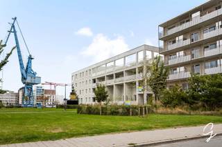 <p><strong>Ligging</strong></p>
<p><strong>Hoogwaardig wonen op een toplocatie nabij Dok Noord in Gent.</strong></p>
<p>Deze stijlvolle woning bevindt zich nabij <strong>Dok Noord</strong>, een van de meest dynamische en gegeerde locaties van Gent. Hier combineert u comfortabel en rustig wonen met alle troeven van de stad binnen handbereik. Winkels, horeca, openbaar vervoer en tal van voorzieningen bevinden zich in de onmiddellijke omgeving, terwijl het historische centrum van Gent vlot bereikbaar is.</p>
<p>De woning maakt deel uit van een hedendaags woonproject en biedt, naast een hoogwaardige private woonomgeving, toegang tot diverse <strong>gemeenschappelijke faciliteiten</strong>. Bewoners kunnen, indien gewenst, gebruikmaken van onder meer een atelier, wasplaats, groentetuin, dakterras en een uitgerust werkatelier met materialen.</p>
<p><strong>Beschrijving</strong></p>
<p>Deze <strong>hoogwaardig afgewerkte woning met 3 slaapkamers, multifunctioneel bureau en 2 terrassen</strong> onderscheidt zich door haar doordachte indeling, luxueuze afwerking en aangename buitenruimtes.</p>
<p>Op het <strong>gelijkvloers</strong> betreedt u de woning via de inkomhal met afzonderlijk toilet. Hier bevindt zich een eerste volwaardige slaapkamer, volledig ingericht met inbouwkasten en een geïntegreerd bureau. Dankzij deze inrichting kan de ruimte in een handomdraai worden omgevormd tot een comfortabele <strong>thuiswerkplek of multifunctionele ruimte</strong>.</p>
<p>Verder vindt u op deze verdieping de eetruimte met een <strong>volledig en luxueus geïntegreerde keuken</strong>. Vanuit deze leefruimte heeft u rechtstreeks toegang tot het ruime en gunstig georiënteerde terras.</p>
<p>De <strong>eerste verdieping</strong> omvat twee bijkomende slaapkamers, een afzonderlijk toilet, een berging en een volledig uitgeruste badkamer. De ruime woonkamer vormt hier een aangename tweede leefzone en sluit aan op het tweede, eveneens goed georiënteerde terras.</p>
<p>Ook aan praktische mobiliteit werd gedacht: bij de woning horen maar liefst <strong>vijf ondergrondse fietsplaatsen</strong>.</p>
<p>Een bijzondere woonst voor wie op zoek is naar <strong>hoogwaardig wonen in Gent</strong>, met drie slaapkamers, thuiswerkmogelijkheden, twee terrassen en uitzonderlijke extra voorzieningen, op een schitterende locatie nabij <strong>Dok Noord</strong>.</p>
<p>Voor meer informatie of een bezoek, contacteer <strong>Gwen Moerman: 0480 641 641</strong></p>