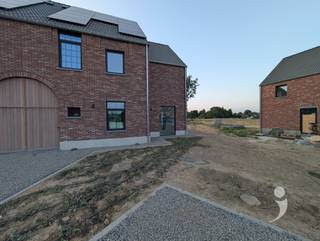 <p><span>Ruime nieuwbouwwoning (halfopen bebouwing) met adembenemende ligging</span></p><p><span>Deze prachtige nieuwbouwwoning, gelegen in een groene en rustige omgeving, wacht op haar eerste bewoners. Een unieke kans om als eerste te genieten van dit gloednieuwe thuis!</span></p><p><span>Bij het binnenkomen valt meteen de ruime inkomhal op, met apart gastentoilet en toegang tot een royale (fietsen)berging van 13,4 m². Via een stijlvolle steellook deur betreedt u de lichtrijke leefruimte, die uitkijkt op de tuin en het zonnige terras (aanleg voorzien begin augustus).</span></p><p><span> </span></p><p><span>De leefruimte gaat vloeiend over in de volledig uitgeruste open keuken, uitgerust met inductievuur, dampkap, dubbele spoelbak, vaatwasser, grote koelkast en oven — en met voldoende opbergruimte om alles netjes weg te bergen. De keuken biedt u verder toegang tot een ruime berging/wasplaats van 6 m².</span></p><p><span> </span></p><p><span>Op de eerste verdieping leidt de brede nachthal naar een verzorgde badkamer met dubbele wastafel, inloopdouche én bad, 4 ruime slaapkamers (13,9 m², 11,8 m², 11,6 m² en 11,4 m²) en een apart toilet. Via een tweede vaste trap bereikt u tot slot de zeer ruime, volledig afgewerkte polyvalente zolder (45 m²) — ideaal als extra slaapkamer, hobbyruimte, leefruimte of speelkamer - en tenslotte de technische ruimte.</span></p><p><span> </span></p><p><span>Buiten biedt de oprit plaats voor 3 tot 4 wagens, en de pas aangelegde voortuin is voorzien van een druppelirrigatiesysteem. De tuin achteraan wordt na de zomer ingezaaid en biedt een weids en ongehinderd zicht op de aangrenzende weilanden — genieten gegarandeerd!</span></p><p><span>De woning is niet gemeubeld en beschikbaar vanaf midden september.</span></p><p><span> </span></p><p><span>Opgelet: de woning wordt momenteel afgewerkt (laatste schilderwerken). De foto's zijn van de reeds afgewerkte, gespiegelde linker woning, ter illustratie.</span></p><p><span>Interesse? </span></p><p><span>Vraag uw bezoek aan via onze website!</span></p><p><span> </span></p><p><span> </span></p>