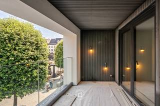 Op een absolute toplocatie in het hart van Aalst bevindt zich dit <strong>stijlvolle, volledig quasi nieuwbouw appartement van 81 m² + 8.4 m² terras. Enkel de buitenmuren van het oorspronkelijke gebouw werden behouden</strong>, waardoor u geniet van een eigentijdse woning met alle comfort van vandaag. Dankzij de lucht-waterwarmtepomp, vloerverwarming en het gunstige EPC woont u niet alleen comfortabel, maar ook bijzonder energiezuinig. Bij het binnenkomen valt meteen de lichtrijke leefruimte op, waar de grote raampartijen een prachtig panoramisch uitzicht bieden over de Grote Markt en de historische binnenstad. <strong>Aansluitend bevindt zich het ruime terras van ca. 9 m², waar u in alle rust kunt genieten van de levendige omgeving. </strong>Er is bovendien voldoende plaats om gezellig buiten te tafelen of te ontspannen. De open, volledig ingerichte keuken sluit naadloos aan op de leefruimte. Verder beschikt het app. over een praktische berging, een ruime slaapkamer, een stijlvolle badkamer, een afzonderlijk gastentoilet en een privatieve kelderberging (verplicht mee aan te kopen), ideaal als extra opslagruimte.<br /><strong>Het appartement maakt deel uit van een kleinschalige residentie met slechts vier appartementen, wat zorgt voor een aangename woonomgeving en beperkte gemeenschappelijke kosten.</strong> Het gebouw is voorzien van een lift en momenteel is er nog geen syndicus aangesteld. Achteraan kan bovendien een autostaanplaats optioneel worden bijgehuurd. <strong>Een bijkomende troef is dat het appartement wordt verkocht onder registratierechten en dus niet onder het btw-stelsel.</strong> De oplevering is op korte termijn voorzien, zodat u binnenkort kunt genieten van een instapklare, energiezuinige woning op een van de meest gegeerde locaties van Aalst.<br />Een unieke opportuniteit voor wie op zoek is naar een kwalitatief afgewerkt appartement met een uitzonderlijk uitzicht, veel lichtinval en alle voordelen van hedendaags wooncomfort, midden in het bruisende stadscentrum.