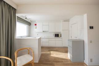 Locatie
Dit ruime appartement geniet van een uitstekende ligging in Deurne, met alle dagelijkse voorzieningen binnen handbereik. Op wandelafstand bevindt zich het Wim Saerensplein, met onder meer een Jumbo-supermarkt op ongeveer 200 meter, naast een bakker, apotheek, bank en diverse horecazaken.
Ook voor ontspanning en groen zit u hier goed: de Bremweide en het aansluitende Ertbruggebos bevinden zich vlakbij, terwijl ook het Rivierenhof en Park Groot Schijn gemakkelijk per fiets bereikbaar zijn.
Voor gezinnen zijn er verschillende scholen in de nabije omgeving. Daarnaast is de bereikbaarheid met het openbaar vervoer bijzonder praktisch: tram 5 stopt voor de deur en brengt u in ongeveer 20 minuten naar het centrum van Antwerpen en in circa 5 minuten naar Wijnegem Shopping.
Dankzij de nabijheid van belangrijke invalswegen en de E34/E313 is ook de wagen vlot verbonden met de rest van Antwerpen en omgeving.
Indeling
Op de eerste verdieping bevindt zich dit ruime (153 m²) appartement, dat momenteel is ingericht als praktijkruimte.
Aan de voorzijde bevindt zich de ruime leefruimte, momenteel opgedeeld in een zitruimte en een afzonderlijke bureauruimte. Deze indeling kan eenvoudig worden aangepast, waardoor opnieuw één grote, open leefruimte ontstaat. Dankzij de kamerbrede raampartijen geniet de ruimte van een aangename natuurlijke lichtinval. De volledige leefruimte is voorzien van een parketvloer. Aan de voorzijde bevindt zich bovendien een terras van ca. 5 m². Eveneens aan de voorzijde bevindt zich de badkamer, uitgerust met een ligbad, een afzonderlijke douche, een enkel wastafelmeubel en een toilet. De open keuken is uitgerust met een elektrisch kookvuur en een koelkast met vriesvak. Aansluitend bevindt zich een praktische berging met aansluitingen voor een wasmachine en droogkast.
Aan de achterzijde telt de huidige indeling drie afzonderlijke behandelruimtes. Deze ruimtes deden voorheen dienst als vier slaapkamers en kunnen bijgevolg opnieuw als slaapkamers worden ingericht. Tevens bevindt zich aan de achterzijde een afzonderlijk gastentoilet. Vanuit de achterzijde is er toegang tot een ruim terras van ca. 17 m², dat zich over de volledige breedte van het appartement uitstrekt. Een privatieve kelderberging is inbegrepen in de verkoopprijs.
Een garagebox kan afzonderlijk worden aangekocht voor € 30.000.
Troeven
• Ruim appartement van ca. 153 m²
• Nabij supermarkten, scholen, openbaar vervoer
• Lift aanwezig
• Kelderberging inbegrepen