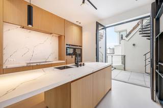 <span>Quares - TREVI Groep presenteert :<br /><br />Indeling</span>: <br />Gelegen in de gegeerde Pacificatiestraat te Antwerpen presenteert deze uitzonderlijke woning zich als een harmonieus samenspel van luxe, comfort en verfijnde architectuur. De totaalrenovatie werd uitgevoerd in 2019 met een eerste ingebruikname in 2022, waarbij elk detail met de grootste zorg werd afgewerkt. Hoogwaardige parketvloeren en stijlvolle gietvloeren versterken de moderne en warme uitstraling, terwijl de overvloedige lichtinval en de zuidgerichte oriëntatie de ruimtes een bijzonder aangenaam karakter geven. De woning is volledig instapklaar met een EPC-score B en conforme elektriciteit, en werd uitgerust met een geavanceerd domoticasysteem, alarmsysteem en digicode, wat veiligheid en gebruiksgemak perfect combineert. Vloerverwarming, aangevuld met radiatoren waar gewenst, zorgt voor optimaal comfort, terwijl een lift die alle niveaus verbindt, van de kelder tot het dakterras op de vierde verdieping.<br /><br />De kelderverdieping omvat een mooie wijnkelder en een praktische wasruimte. Op het gelijkvloers bevindt zich een inkomhal met toegang tot een volwaardig geïntegreerd “appartement”: een leefruimte met volledig uitgeruste keuken, een aparte slaapkamer met ensuite badkamer voorzien van inloopdouche en een koertje van 4,65 m². Deze ruimte leent zich perfect als kangoeroewoning, gastenverblijf of derde slaapkamer, en maakt integraal deel uit van de woning. De eerste verdieping herbergt een royale slaapkamer van circa 18 m² met dressing en een stijlvolle badkamer met inloopdouche. Op de tweede verdieping bevindt zich een tweede ruime slaapkamer van ongeveer 22 m² met ensuite badkamer, uitgerust met zowel bad als inloopdouche.<br /><br />De derde verdieping vormt het hart van de woning met een lichtrijke leefruimte en open keuken, die rechtstreeks toegang biedt tot een terras van 8 m². Via een trap (of met de lift) bereikt u het vierde niveau, waar twee ruime zonneterrassen verbonden worden door een unieke zomerkeuken/binnenlounge met schuifdeuren aan beide zijden. Deze harmonieuze buitenbeleving biedt een prachtig, vrij zicht over de omliggende daken en volledige privacy zonder inkijk. <br /><br />De slaapkamers zijn voorzien van maatwerk inbouwkasten en de woning ademt doorheen alle verdiepingen een gevoel van rust en verfijning.<br /><br />Daarnaast bestaat de mogelijkheid tot aankoop van twee ondergrondse binnenparkings onder de Carrefour: een afgesloten garagebox aan 65.000 euro en een autostaanplaats aan 45.000 euro, beide optioneel maar beschikbaar.<br /><br /><br /><span>Omgeving</span>:<br />De Pacificatiestraat geniet van een uiterst gegeerde ligging op het Zuid, één van de meest dynamische en stijlvolle buurten van Antwerpen. Hier woont u in een rustige straat met een residentieel karakter, terwijl u zich op wandelafstand bevindt van tal van trendy restaurants, gezellige cafés, boetieks en culturele hotspots. De nabijheid van het Museum van Schone Kunsten, de vernieuwde Scheldekaaien en verschillende parken zorgt voor een aangename combinatie van stadsleven en ontspanning.<br /><br />Dankzij de uitstekende bereikbaarheid met zowel het openbaar vervoer als belangrijke invalswegen verplaatst u zich vlot in en rond de stad. Fietsers en wandelaars genieten bovendien van de nabijgelegen groene zones en de levendige pleinen die deze buurt zo aantrekkelijk maken. De omgeving staat bekend om haar architecturale charme, brede straten en kwalitatieve residenties, wat bijdraagt aan een exclusieve en aangename woonbeleving.