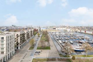 Schitterend appartement met panoramisch zicht op het Eilandje en Kempischdok.<br /><br />Gelegen op de achtste verdieping van de gloednieuwe residentie 'Doktoren' kijkt dit appartement uit over de Stad. <br /><br />U betreedt dit lichtrijke hoekappartement via de inkomhal met apart toilet. De ruime leefruimte biedt een panoramisch zicht over het Eilandje en de jachthaven. De open keuken is voorzien van alle comfort en gebruikelijke toestellen. De twee terrassen zijn rechtstreeks toegankelijk via de woonruimte.<br />De nachthal leidt u naar de masterslaapkamer met dressingmogelijkheid en douchekamer. Verder beschikt het appartement over twee slaapkamers en een separate badkamer met bad, toilet en wastafel.<br /><br />Een autostaanplaats dient verplicht bij gehuurd te worden aan 100 EUR/maand. <br /><br />Bijzonderheden: <br />- Kan gehuurd worden op vennootschap <br />- Recent appartement<br />- Mooie vergezichten over de Stad, Eilandje en de Jachthaven<br />- Bakkerij, slagerij, supermarkt en HoReCa in de directe nabijheid<br />- Ruim gemeenschappelijk dakterras op de 23e verdieping waar men gebruik van kan maken.