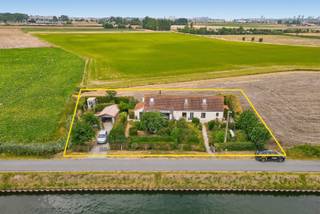 Ontdek deze uitzonderlijke vrijstaande woning op een prachtig perceel van ca. 984 m², idyllisch gelegen langs het kanaal Nieuwpoort-Plassendale op slechts enkele kilometers van Middelkerke en Oostende. Dankzij de royale tuin rondom de woning geniet u hier van een uniek en vrij uitzicht over het water en de uitgestrekte achterliggende velden tot in Middelkerke. Een locatie waar rust, ruimte en natuur perfect samenkomen.<br /><br />Bij het betreden van de woning wordt u verwelkomd in een ruime en stijlvolle inkomhal met apart gastentoilet. De open vide creëert meteen een aangenaam gevoel van ruimte en licht. De lichtrijke leefruimte, met gezellige zit- en eethoek, vormt het hart van de woning en sluit naadloos aan op de volledig ingerichte open keuken, voorzien van alle nodige toestellen met aanpalende koele bergruimte.<br />Daarnaast beschikt de woning over een sfeervol leeshoekje met een prachtig uitzicht op het hinterland, een praktische en ruime wasberging met extra douche, een polyvalente kamer die momenteel is ingericht met een Finse sauna en een handige kelderberging.<br /><br />Op de eerste verdieping bevinden zich een ruime overloop, twee gezellige slaapkamers en een verzorgde badkamer uitgerust met een ligbad, lavabo en toilet.<br /><br />Ook buiten heeft deze eigendom heel wat te bieden. U beschikt er over twee afzonderlijke tuinbergingen, een vrijstaande garage met elektrische sectionaalpoort en een aansluitende fietsenberging. De ruime tuin biedt bovendien tal van mogelijkheden om optimaal te genieten van de unieke ligging en de rustige omgeving.<br />Bent u op zoek naar een instapklare woning met karakter, een uitzonderlijke ligging en een adembenemend uitzicht? Dan is deze eigendom absoluut een bezoek waard.<br />Vraag vandaag nog uw bezoek aan voor onze kijkdag op zaterdag 22 augustus tussen 14.00 u en 16.00 u, uitsluitend op afspraak.<br /><br />Richtprijs: De vermelde prijs betreft een richtprijs. Elk bod, zowel hoger als lager dan deze richtprijs, wordt voorgelegd aan de eigenaars, die vrij zijn om dit al dan niet te aanvaarden.<br /><br />EPC: 240 kWh/m² - UC: 6898463 - Gvg Lwag Gvkr Gvv Gmr - Ref. MI25003