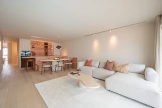 Dit appartement op de 4e verdieping bevindt zich op een strategische centrumlocatie nabij de Lippenslaan en de Kustlaan. De winkels liggen voor de deur en het strand bevindt zich op korte wandelafstand. Het interieur werd volledig vernieuwd, waarbij gekozen is voor een eigentijdse stijl die afwijkt van de standaard renovatie. Bovendien is het volledige appartement uitgerust met vloerverwarming, wat zorgt voor een aangenaam en constant leefcomfort.<br /><br />Bij binnenkomst valt meteen de lichtinval in de woonkamer op. De open keuken staat in direct contact met de leefruimte en is voorzien van een royaal werkblad in natuursteen. Dit materiaal keert ook terug in de badkamers, wat zorgt voor een mooie samenhang doorheen de woning. Aan de keuken is een vaste zitbank geïntegreerd. Vanaf deze plek kijkt u zijdelings uit richting het Lichttorenplein en de zee.<br /><br />Het plan telt drie slaapkamers. De twee ruime slaapkamers beschikken elk over een eigen badkamer en op maat gemaakte dressingkasten die zorgen voor rust en esthetiek. Beide vertrekken geven rechtstreeks toegang tot het grote zonneterras aan de achterzijde. De derde kamer is slim benut als slaaphoek met een ingebouwd stapelbed. Een wand in gekleurd glas brengt hier daglicht binnen zonder in te boeten op privacy.<br /><br />Dit eigendom op Kustlaan 16 combineert een doordachte architectuur met een sterke centrumlocatie. Het is daarmee de ideale kans voor wie op zoek is naar een waardevolle vastgoedinvestering of een comfortabel tweede verblijf aan de kust.<br /><br />Een bezoek inplannen kan via 0472 26 65 17 of info@immonano.be.