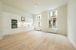 Gelijkvloersappartement met tuin op centrale ligging in het stadscentum in een rustige straat. Het gebouw is volledig gerenoveerd en is gelegen op wandelafstand van winkels, restaurants, universiteit. Het appartement is gerenoveerd met oog voor detail en oog voor de toekomst. Afwerking met hoogwaardige materialen. <br /><br />Indeling van het appartement:<br />Via de gemeenschappelijke inkomhal, betreed je het appartement en kom je terecht in de ruime living op parket (+/- 50 m²). Open ingerichte keuken voorzien van kasten, kookfornuis, frigo, dampkap, vaatwasser en oven. <br />Achteraan bevindt zich de ruime slaapkamer op parket met mogelijkheid tot inrichting van een dressing (+/- 22 m²). Naast de slaapkamer bevindt zich de ruime ingerichte badkamer die voorzien is van toilet, wastafel met meubel en inloopdouche. <br />Terras +/- 7 m² en tuin +/- 16,8 m² (wordt nog aangelegd).<br /><br />Kelderberging en fietsenstalling. <br /> 
