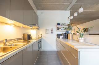 <p>Op absolute toplocatie op het Eilandje bevindt zich dit uitzonderlijk loft- appartement in een karaktervol brutalistisch gebouw. Dit appartement is een uitgelezen kans voor wie zoekt naar een instapklare woning in een levendige omgeving, met alle voorzieningen van de bruisende stad Antwerpen binnen handbereik. Het uitzonderlijk zicht geeft geeft een dagelijks gevoel van rust en ruimte.<br /><br /><strong>Indeling: </strong><br />Het appartement is zowel op energetisch vlak als op bouwtechnisch vlak doordacht gebouwd en biedt flexibele mogelijkheden qua indeling.<br />De open indeling wordt gekenmerkt door een lichte woonkamer die naadloos overgaat in de volledige geïnstalleerde keuken en samen genieten van een prachtig zicht op het water. Het zichtbare betonnen plafond geeft het interieur een architecturale uitstraling. De slaapkamer biedt een serene ruimte om tot rust te komen met aansluitend een gezellig terras welke visueel bij de leefruimte betrokken wordt door het betegeld gangpad. Op het terras geniet je van de namiddag en avondzon. De moderne badkamer bestaat uit een ligbad, douche en aansluiting voor de wasmachine en droogkast. <br /><br /><strong>Bijzonderheden:</strong></p>
<ul>
<li>Energielabel A -Zeer goed geïsoleerd. </li>
<li>Massieve inkomdeur met driepunts slotbeveiliging.</li>
<li>Hoge afwerkingsgraad, waaronder massief parketvloer.</li>
</ul>