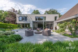 <h3>Exclusieve architectenvilla op toplocatie in villawijk De Lint</h3>
<p>Op een prachtig zuidwestgericht perceel, op wandelafstand van het unieke natuurgebied De Liereman, bevindt zich deze hedendaagse en onder architectuur gebouwde villa. Deze uitzonderlijke woning combineert tijdloze architectuur, royale leefruimtes en een hoogwaardig afwerkingsniveau met een uitstekende bereikbaarheid. Zowel Eindhoven als Antwerpen bevinden zich op slechts ca. 25 minuten rijden, waardoor u geniet van het beste van twee werelden: rust, natuur en een vlotte verbinding.</p>
<p>Bij aankomst wordt u verwelkomd in een ruime inkomhal met vestiaire en gastentoilet. Via stijlvolle dubbele deuren betreedt u de indrukwekkende woonkamer, waar de grote raampartijen een panoramisch zicht bieden op de prachtig aangelegde tuin. Het overvloedige natuurlijke licht en de fraaie tuinzichten creëren een unieke woonbeleving. Aansluitend bevindt zich een open ruimte die perfect dienst kan doen als bureau of leeshoek, open van karakter maar toch afzonderlijk van de leefruimte.</p>
<p>De sfeervolle doorkijkhaard vormt een elegante verbinding tussen de woonkamer en de royale leefkeuken. Deze keuken verkeert in perfecte staat van onderhoud, is uitgerust met kwalitatieve toestellen, beschikt over een groot werkblad en biedt plaats aan een ruime eettafel. Dankzij de grote schuiframen loopt binnen naadloos over in buiten. Achter de keuken bevinden zich een praktische bijkeuken en een aparte wasruimte. De inpandige dubbele garage met automatische poort en personenlift vervolledigt het comfort op het gelijkvloers.</p>
<p>Op de verdieping geeft de royale nachthal toegang tot de indrukwekkende master suite met inloopdressing en een luxueuze badkamer. Daarnaast zijn er nog twee volwaardige slaapkamers met een gedeelde badkamer. De ruime studiekamer kan eenvoudig worden ingericht als vierde slaapkamer en beschikt bovendien over een eigen terras.</p>
<p>Ook buiten weet deze villa te imponeren. De volgroeide, volledig omheinde tuin biedt optimale privacy en vormt een waar groen paradijs. Meerdere zonneterrassen en een overdekt terras nodigen uit om in alle seizoenen van het buitenleven te genieten. Het extra losstaande garagegebouw biedt bijkomende mogelijkheden voor wagenliefhebbers, hobbyruimte of extra opslag.</p>
<p>Naast het uitzonderlijke wooncomfort onderscheidt deze villa zich door haar onderhoudsvriendelijke karakter. Dankzij de duurzame aluminium raamprofielen en de kwalitatieve gevels in gevelsteen zijn er geen schilderwerken aan het buitenschrijnwerk of de buitenmuren nodig, wat resulteert in een stijlvolle uitstraling met een minimum aan onderhoud.<br /><br /><strong>Een uitzonderlijke villa voor wie ruimte, comfort, privacy, kwaliteit en een onderhoudsarme woonomgeving weet te waarderen.</strong></p>
<h3>Troeven van deze woning</h3>
<ul>
<li>Wandelafstand van natuurgebied De Liereman</li>
<li>Zuidwestgericht perceel met optimale bezonning</li>
<li>Personenlift naar de verdieping</li>
<li>Vloerverwarming op gelijkvloers én verdieping</li>
<li>Inpandige dubbele garage met automatische poort</li>
<li>Extra losstaand garagegebouw met bergzolder</li>
<li>Alarmsysteem</li>
<li>Zonnescreens</li>
<li>Fraai aangelegde, volledig omheinde tuin</li>
<li>Grote terrassen en overdekt, verwarmd terras</li>
</ul>