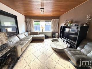 Deze goed onderhouden open bebouwing combineert een comfortabel ruimtegevoel met een groot perceeloppervlak van 952 m². Dankzij de functionele indeling, drie slaapkamers (één momenteel als dressing ingericht) en een "asbestveilig" attest biedt deze woning een uitstekende en betrouwbare basis.<br /><br />Indeling:<br />Via de inkomhal met trap naar de verdieping betreedt u het gelijkvloers. Aan de voorzijde bevindt zich de multifunctionele voorkamer, met een karakteristieke erker, die door de grote raampartijen geniet van veel natuurlijk lichtinval en perfect kan worden ingericht als bureau, aparte speelhoek of als gelijkvloerse slaapkamer. Via een glazen schuifdeur is er verbinding met de achterliggende, centrale zithoek waar de inbouwcassette voor een gezellige warmte zorgt. Aansluitend bevindt zich de leefkeuken die meer dan voldoende ruimte biedt voor een grote eettafel. Vanuit de keuken is er direct zicht op en toegang tot het terras en de tuin. De badkamer is praktisch ingericht met een ligbad met douchecombinatie, een wastafelmeubel en de nodige voorzieningen voor wasmachine en droogkast. De berging, het toilet en de ruime garage maken het gelijkvloers compleet<br /><br />Op de eerste verdieping geeft de nachthal met een onderhoudsvriendelijke laminaatvloer toegang tot drie slaapkamers. De master bedroom beschikt over een grote, ingebouwde kastenwand die slim is ingewerkt onder de dakschuinte. De overige twee kamers doen momenteel dienst als kinderkamer en dressing/sportruimte. Op de verdieping bevindt zich een tweede toilet. Via een zolderluik in de nachthal is de stockagezolder bereikbaar. Tot slot beschikt de woning over een kleine voorraadkelder.<br /><br />Buitenruimte:<br />De achtertuin is volledig omheind en is voornamelijk ingericht met een groot gazon met achteraan hondenrennen. Aansluitend aan de achterbouw bevindt zich een verhard terras. De brede kiezeloprit aan de rechterzijde leidt naar de vrijstaande, garage en garandeert ruime parkeergelegenheid op eigen terrein.<br /><br /><span><em>*De vermelde oppervlaktes zijn indicatief. JM Vastgoed kan niet verantwoordelijk gesteld worden voor de juistheid van de verstrekte gegevens.</em></span>